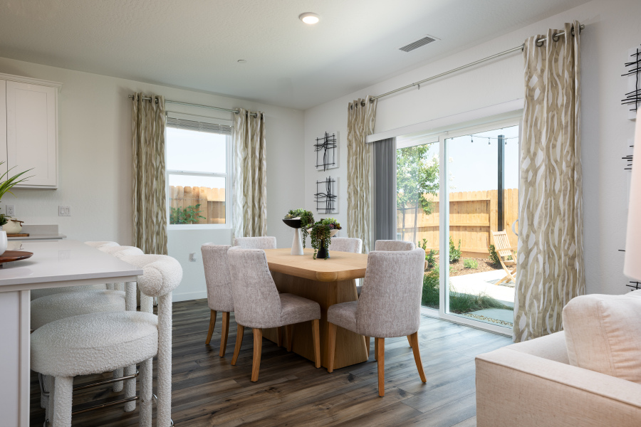 A room with a table chairs and a large window.