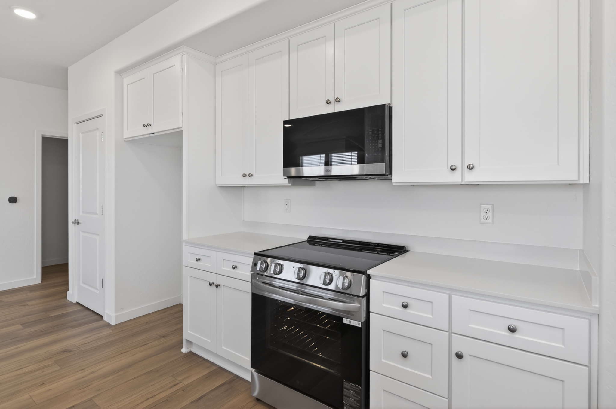 A kitchen with white cabinets.