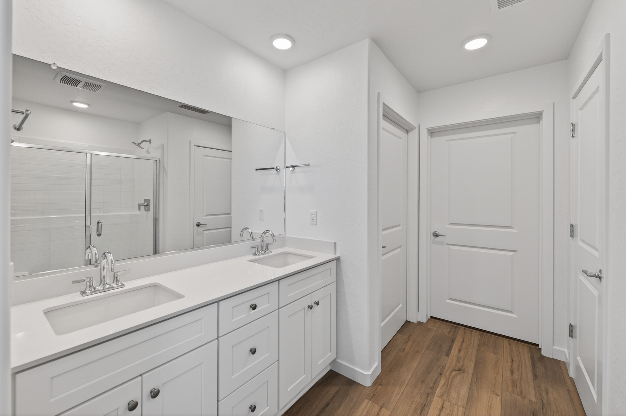 A bathroom with white cabinets.