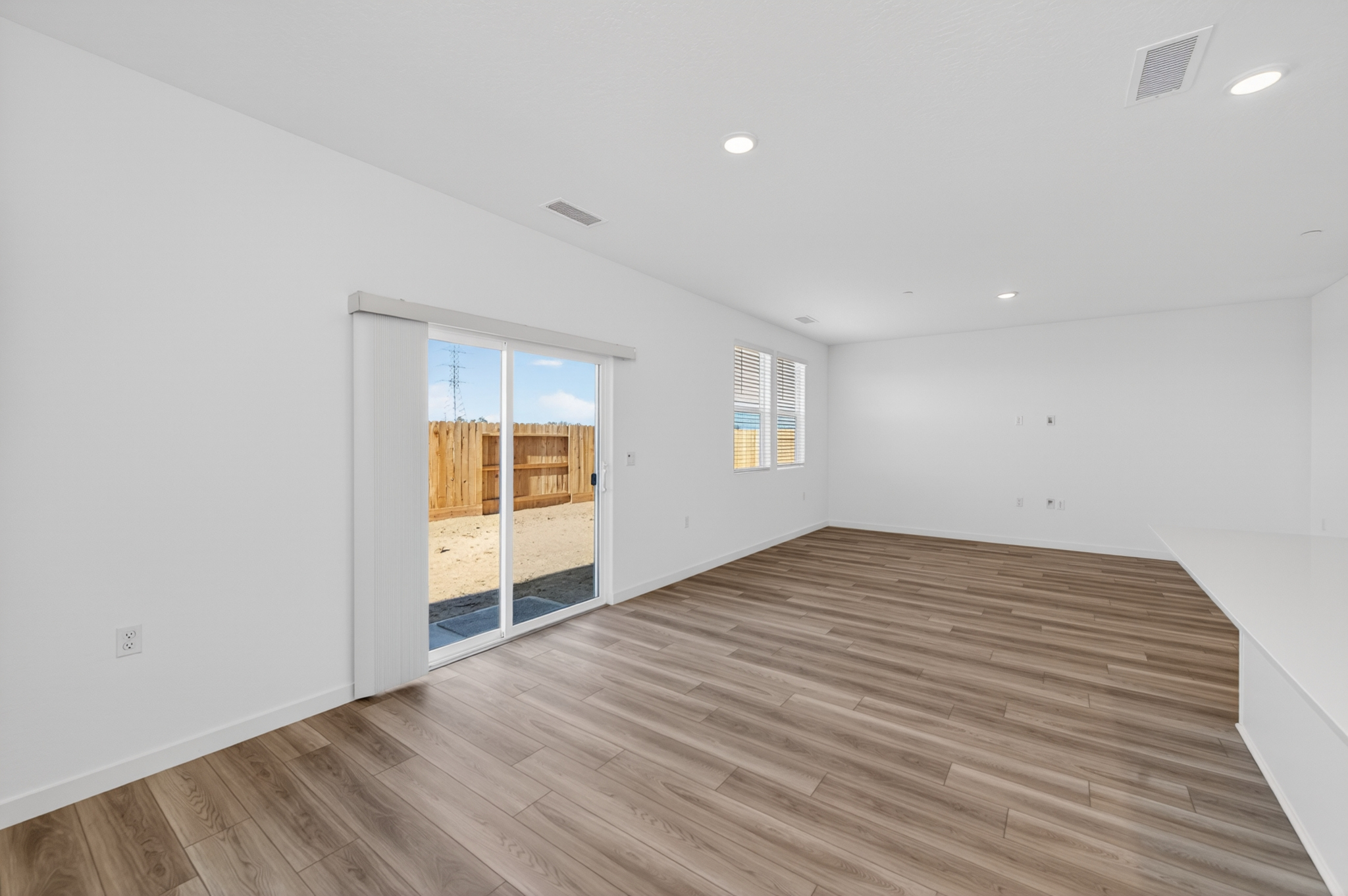 A room with a wood floor and a wood floor with a window.