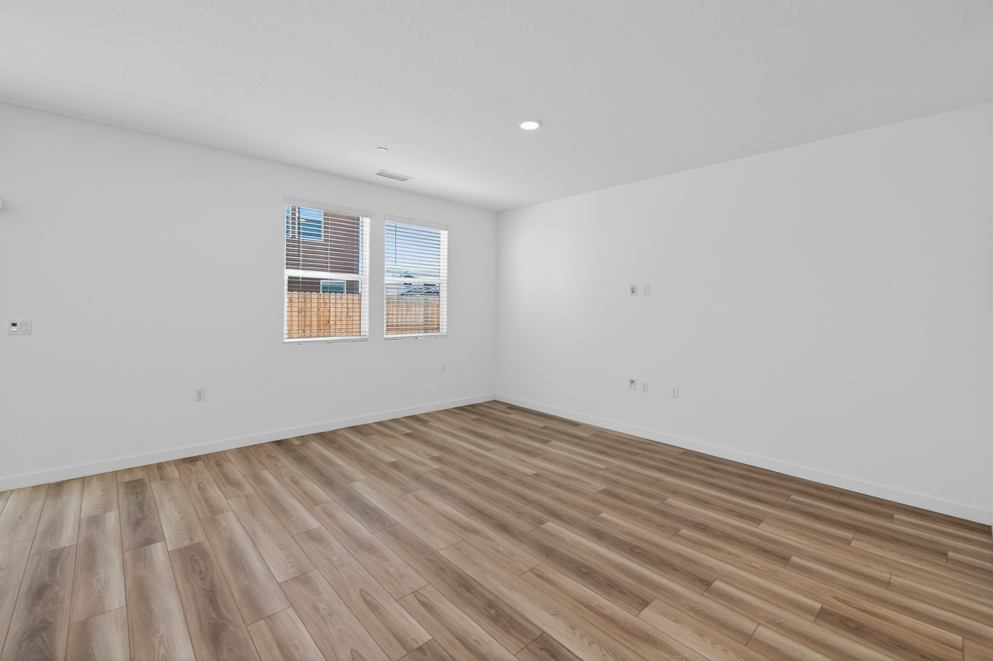 A room with a wood floor and a window.