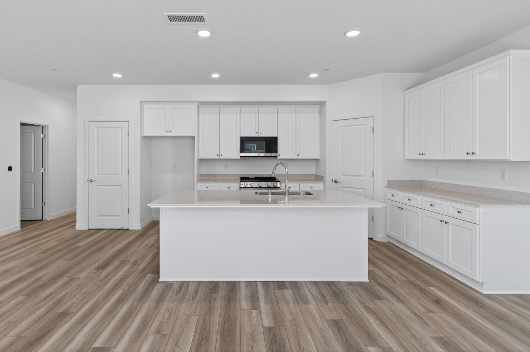 A kitchen with white cabinets.