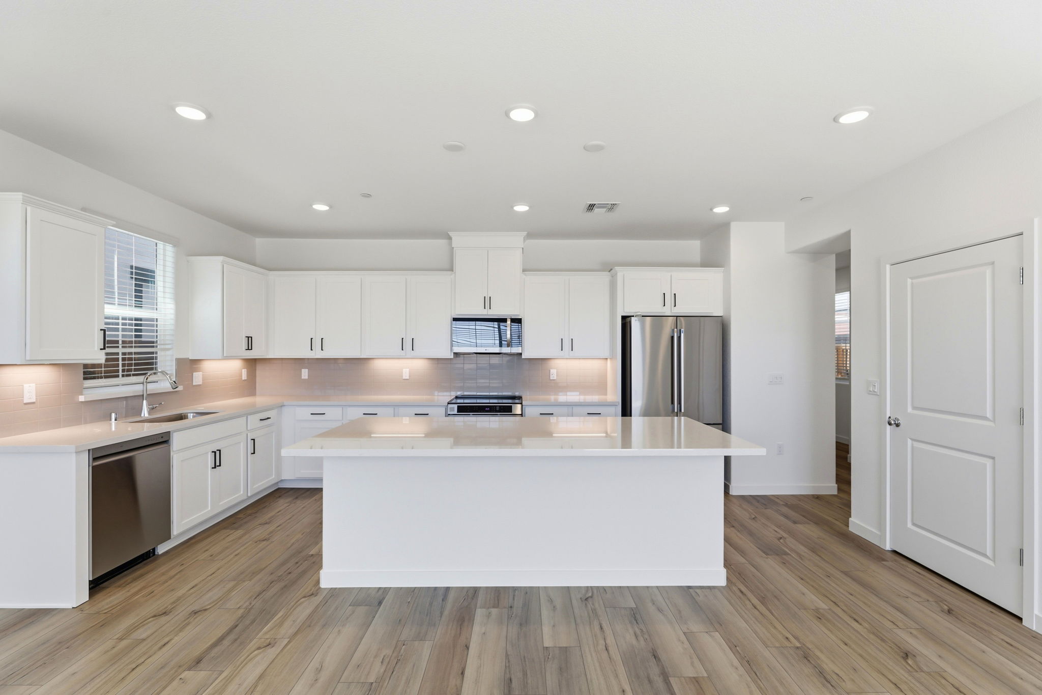 A kitchen with white cabinets.