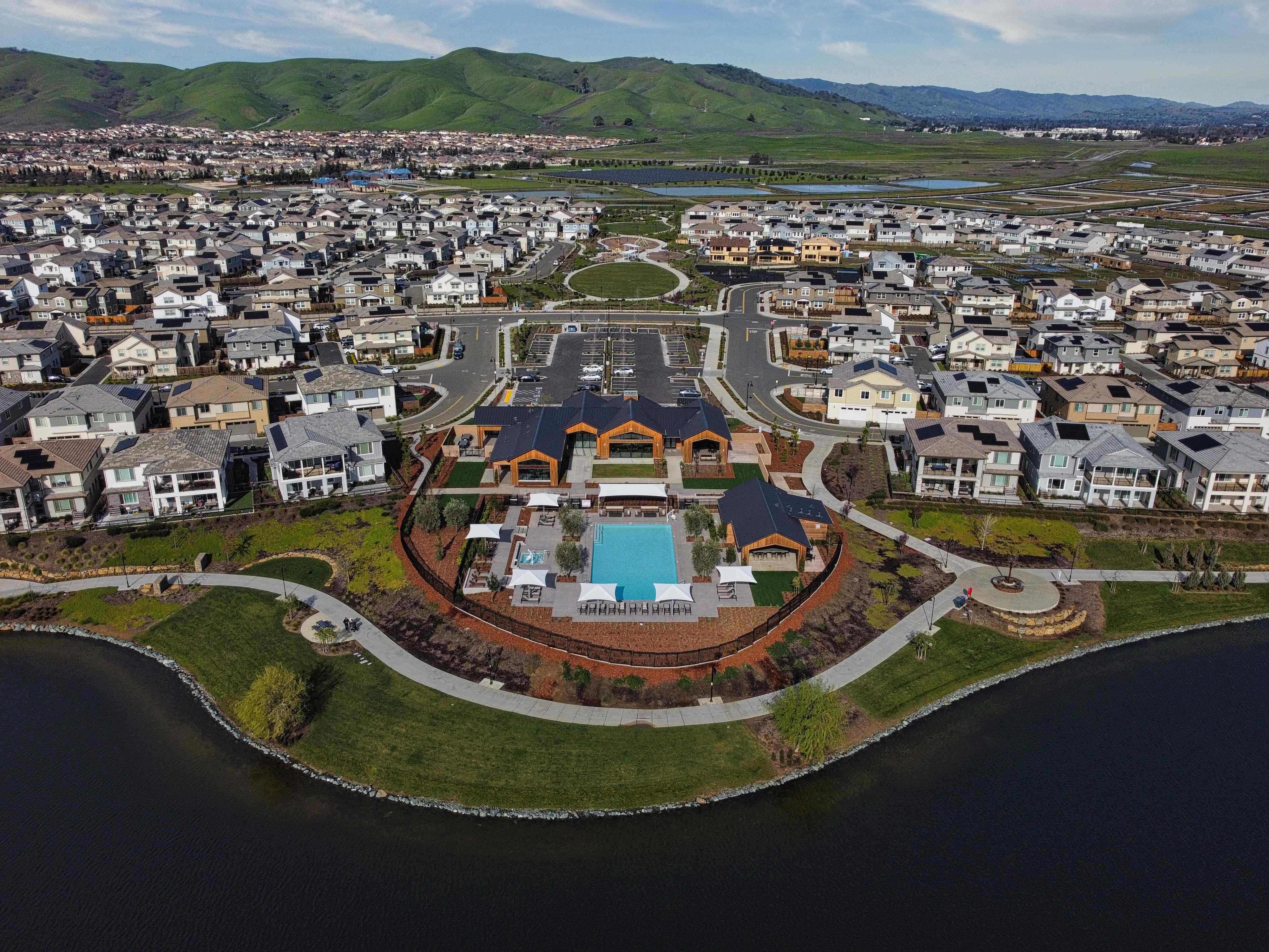 A large stadium with a field in front of it.