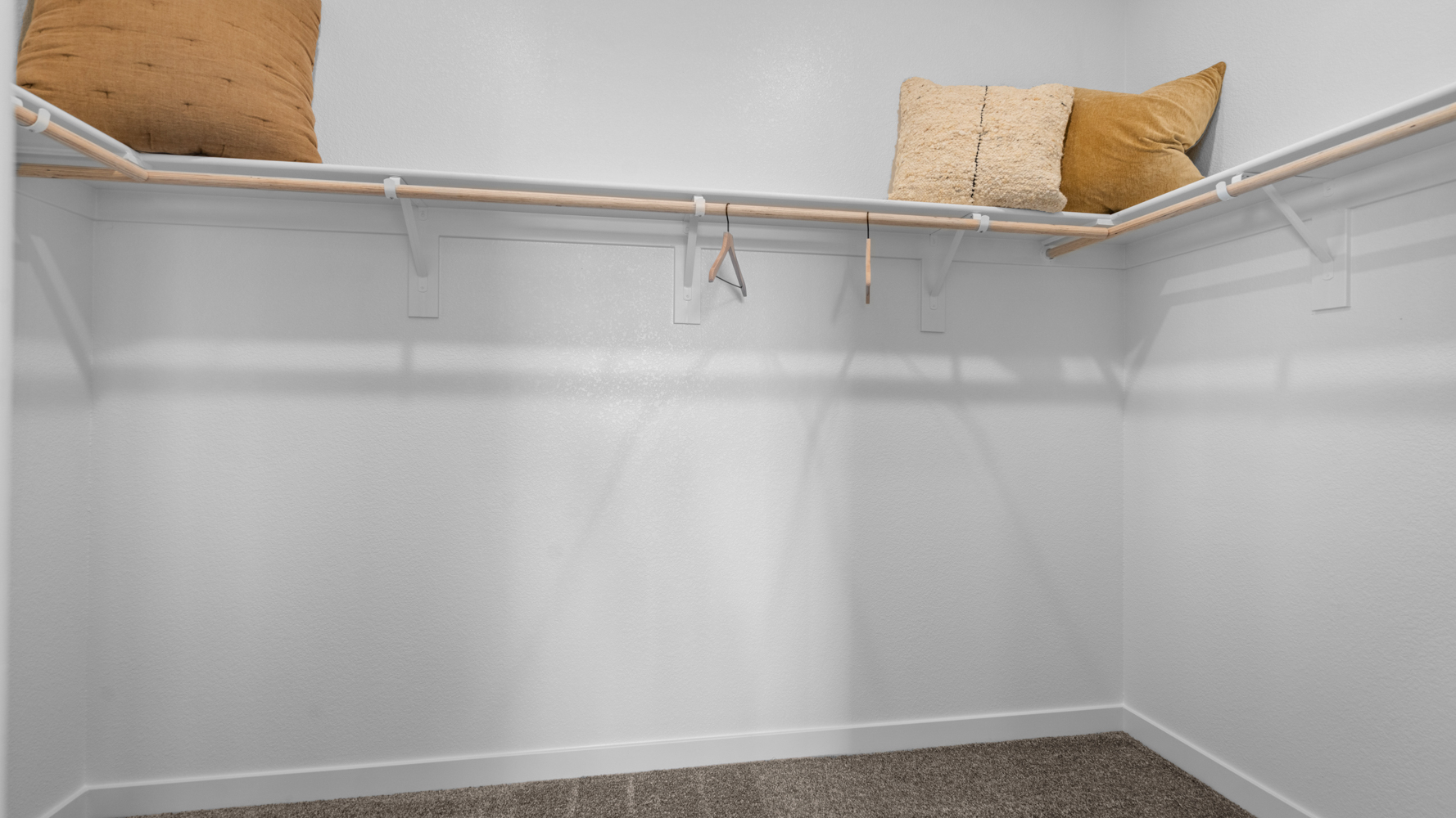 A white wall with a brown pillow and a brown pillow.