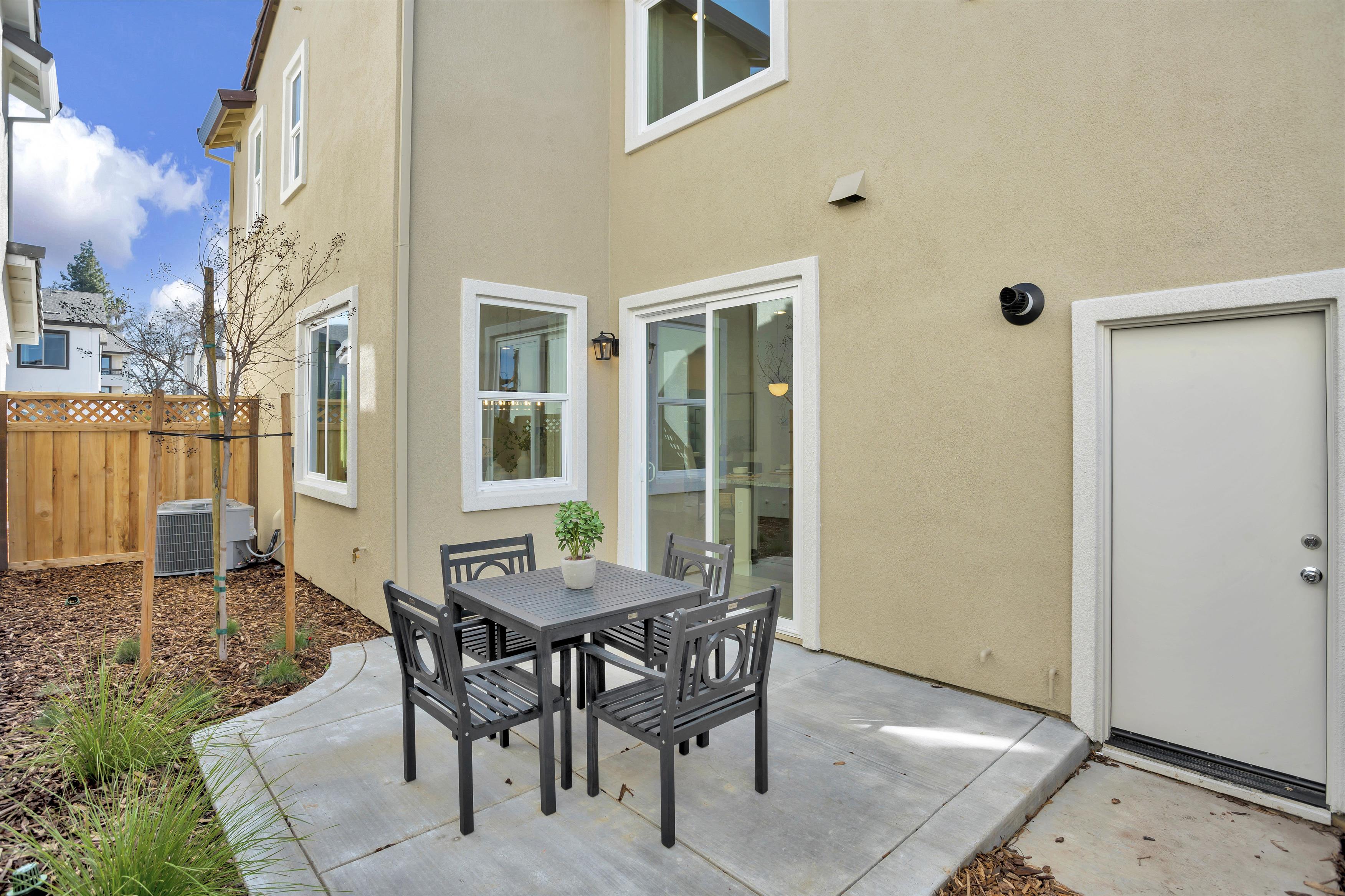 A table and chairs outside a house.