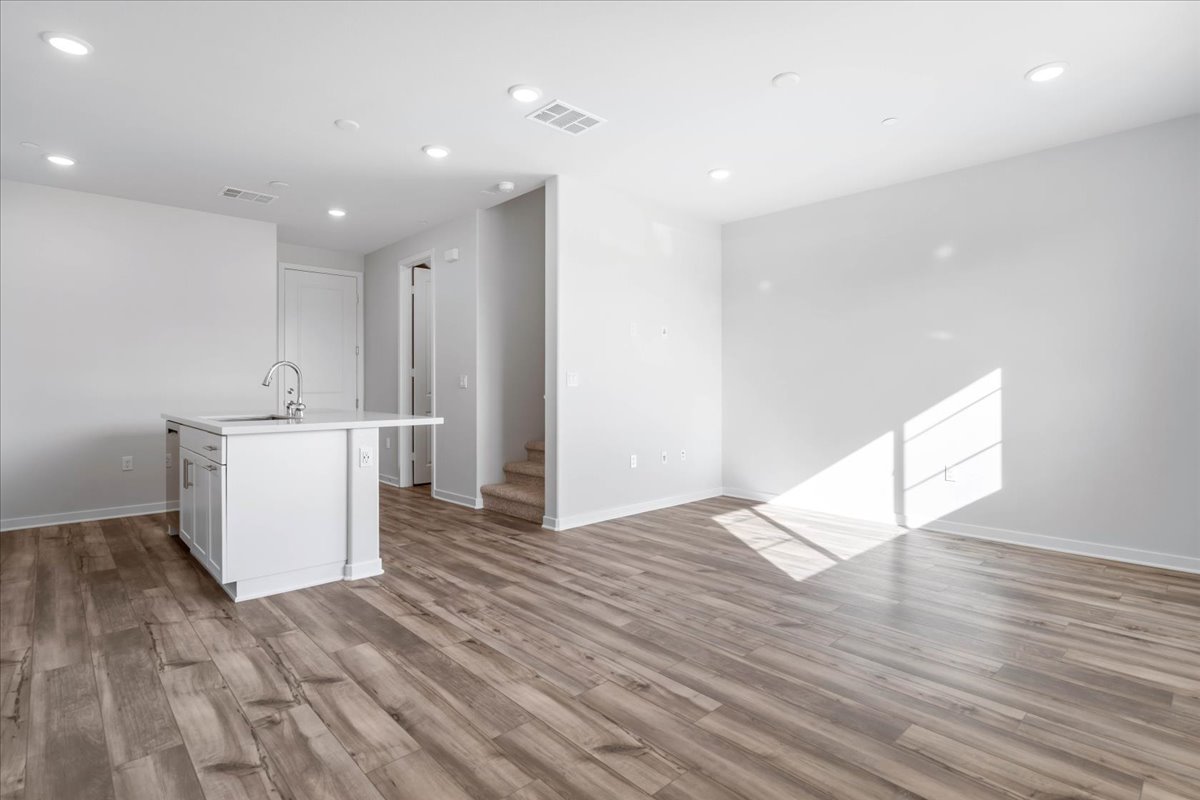 A large empty room with white cabinets.