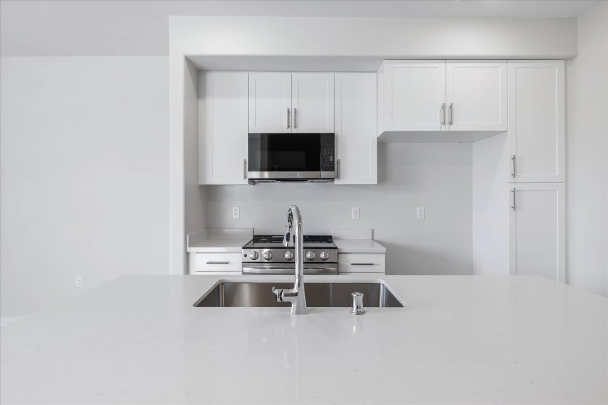 A kitchen with white cabinets.
