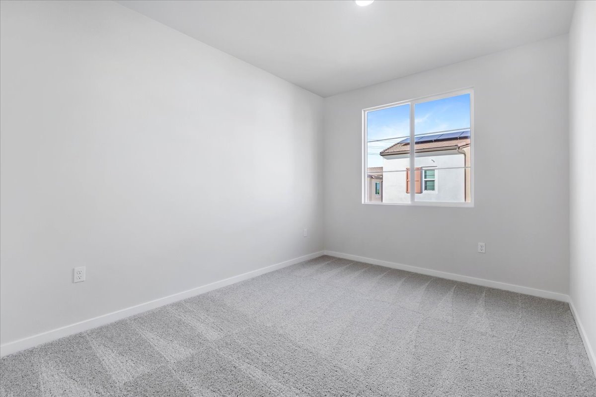 A room with a window and a carpet.