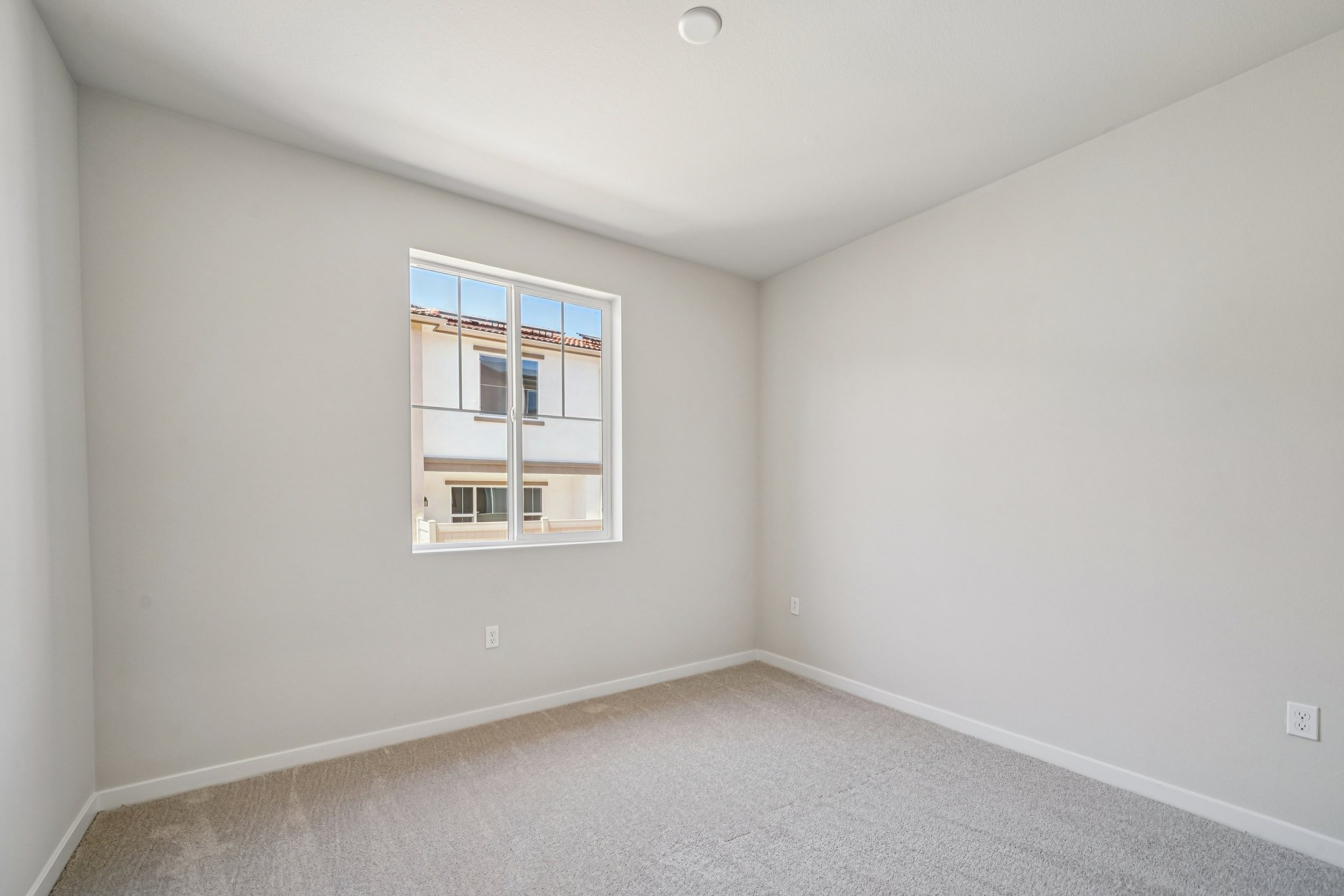 A room with a window and a carpet.