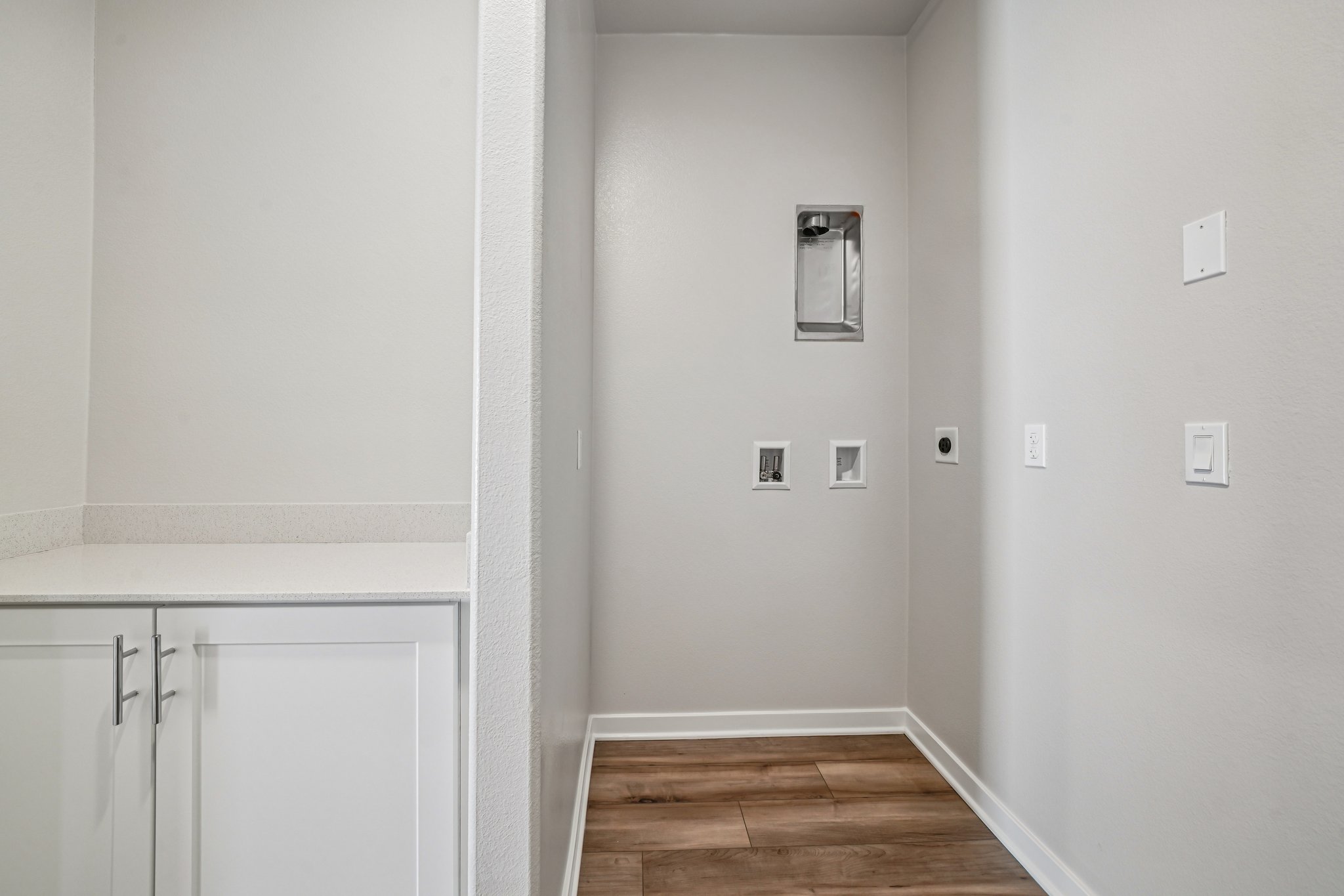 A white room with a wood floor.