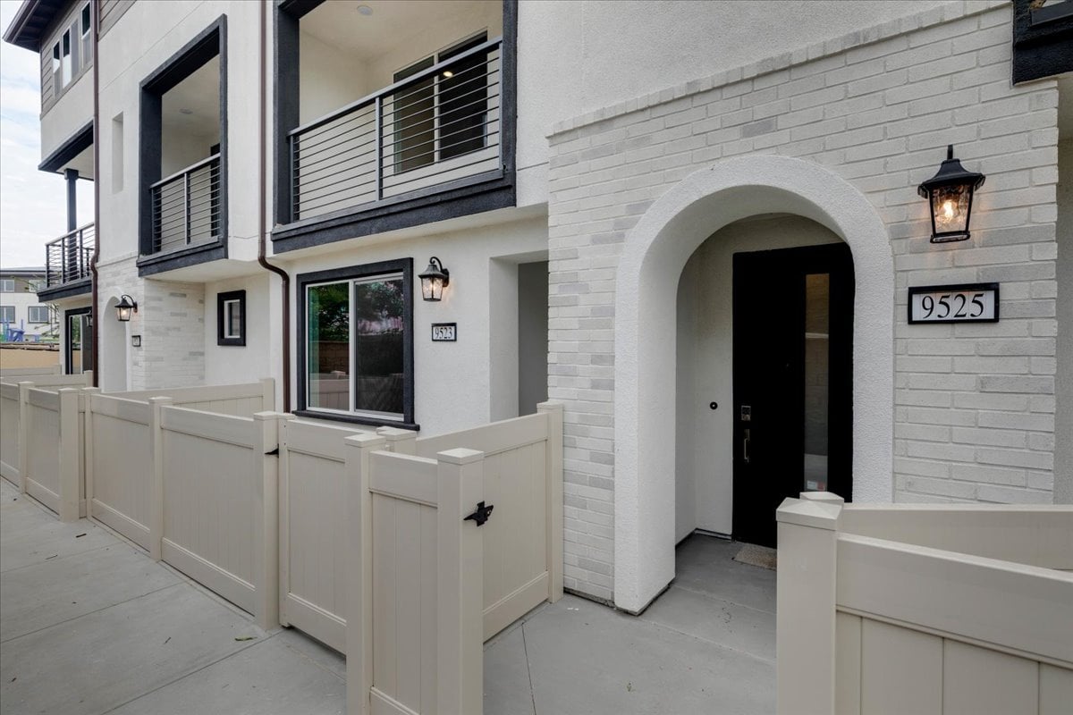 A white building with a white fence.