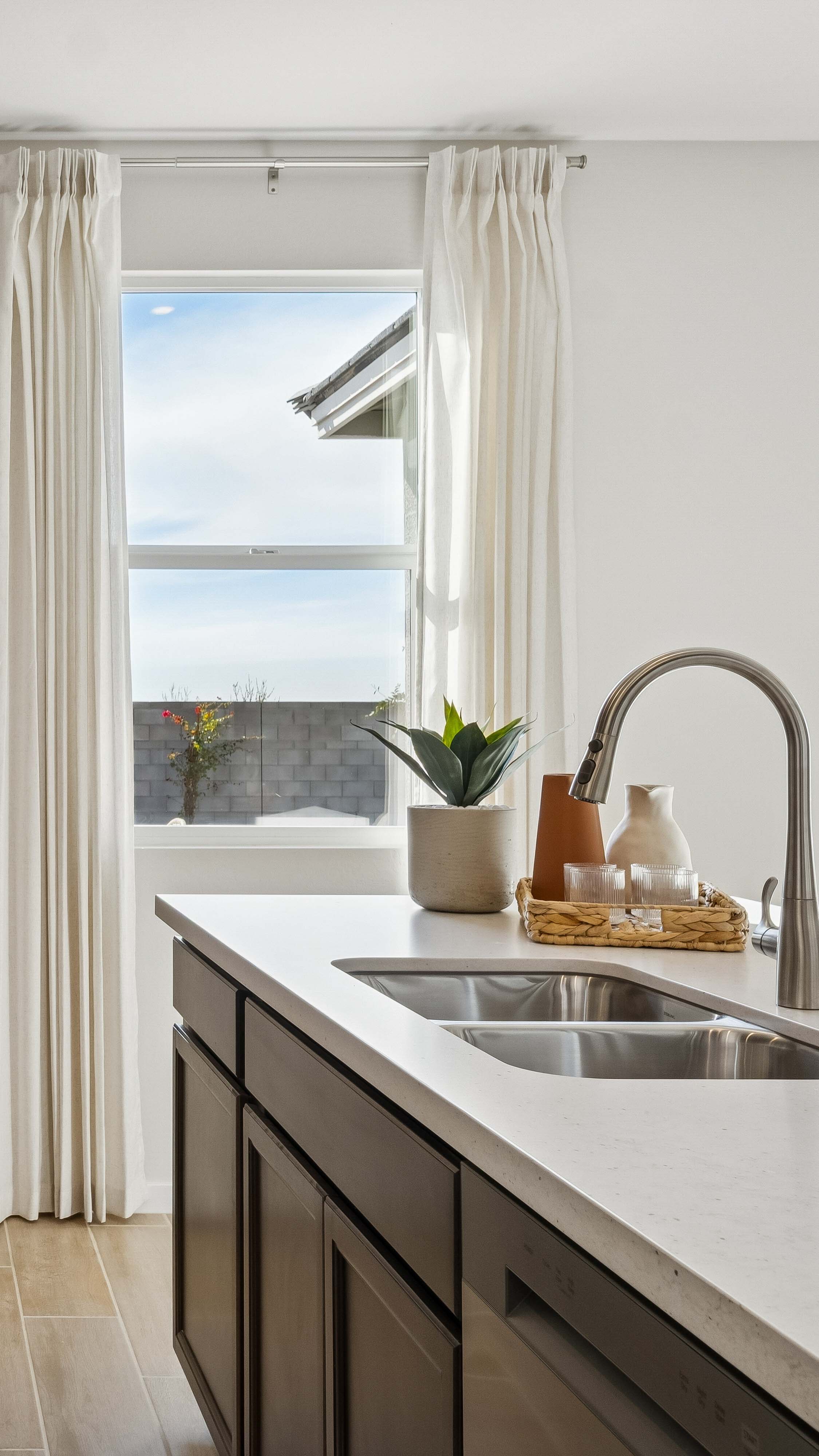 Kitchen with 3cm counters, undermounted sink, and deep espresso wood cabinetry  - New construction homes for sale Goodyear AZ Resort style amenities & founder incentives to the lucky few first homeowners.