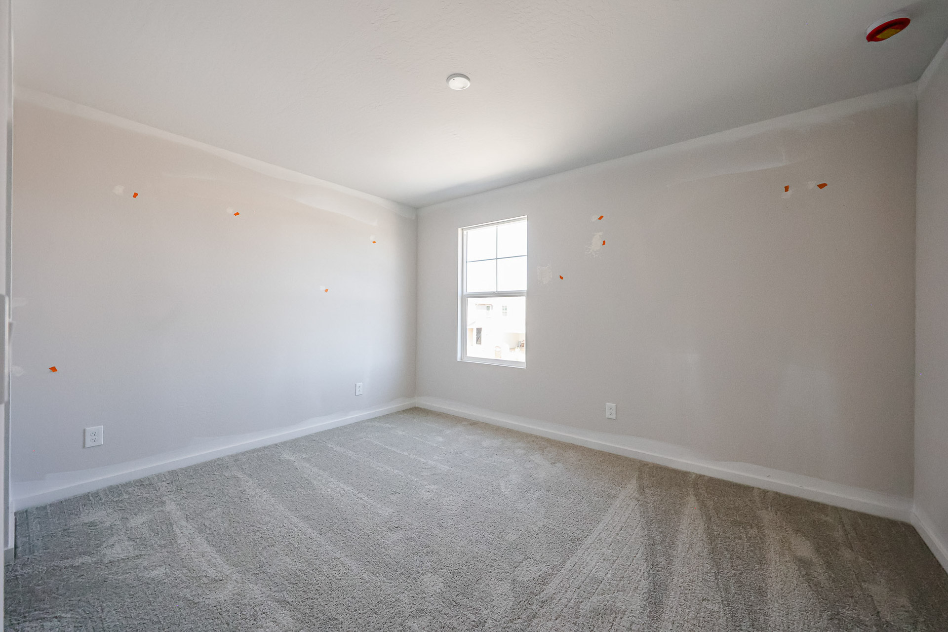 A room with a window and a carpet.