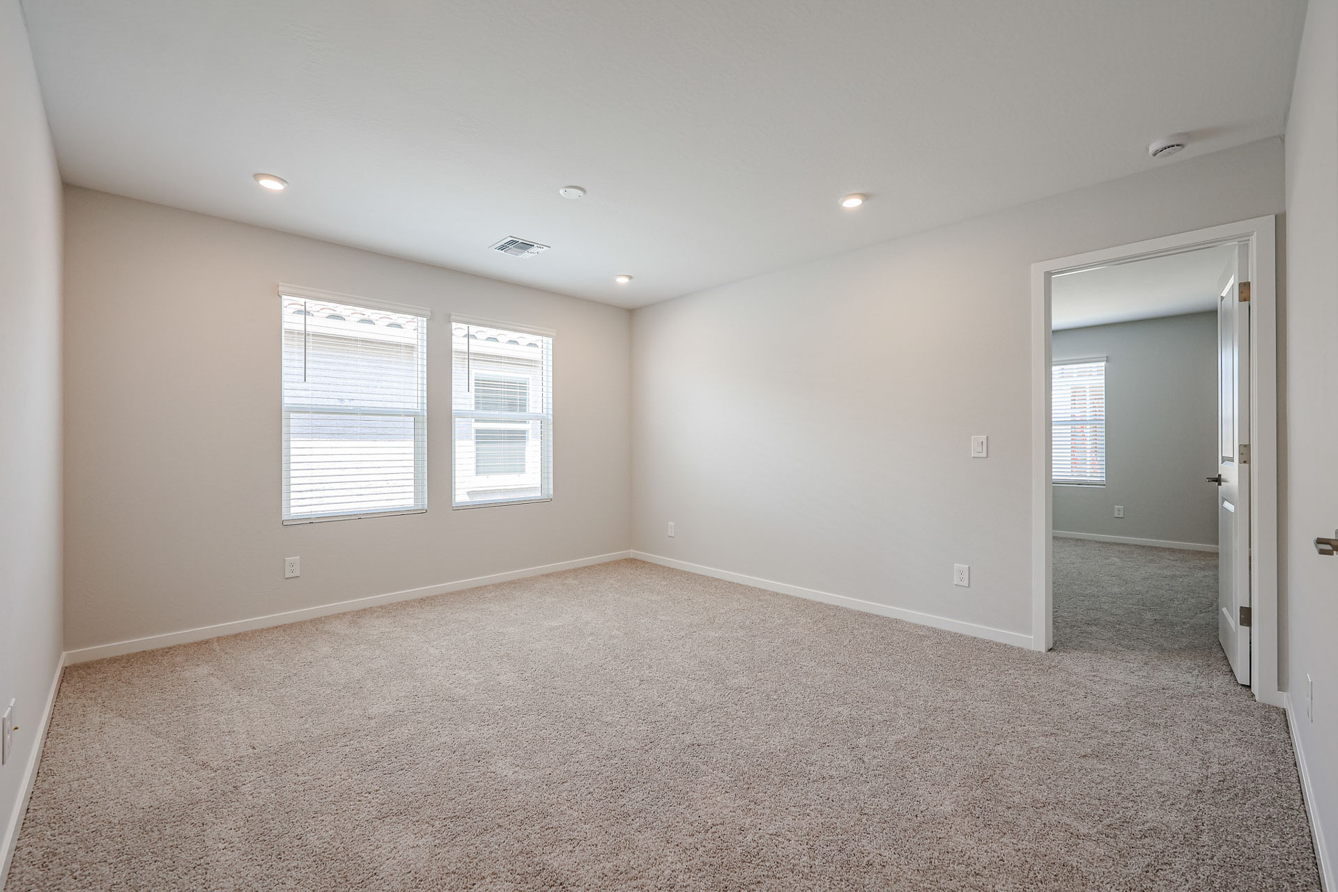 A room with a carpet and windows.