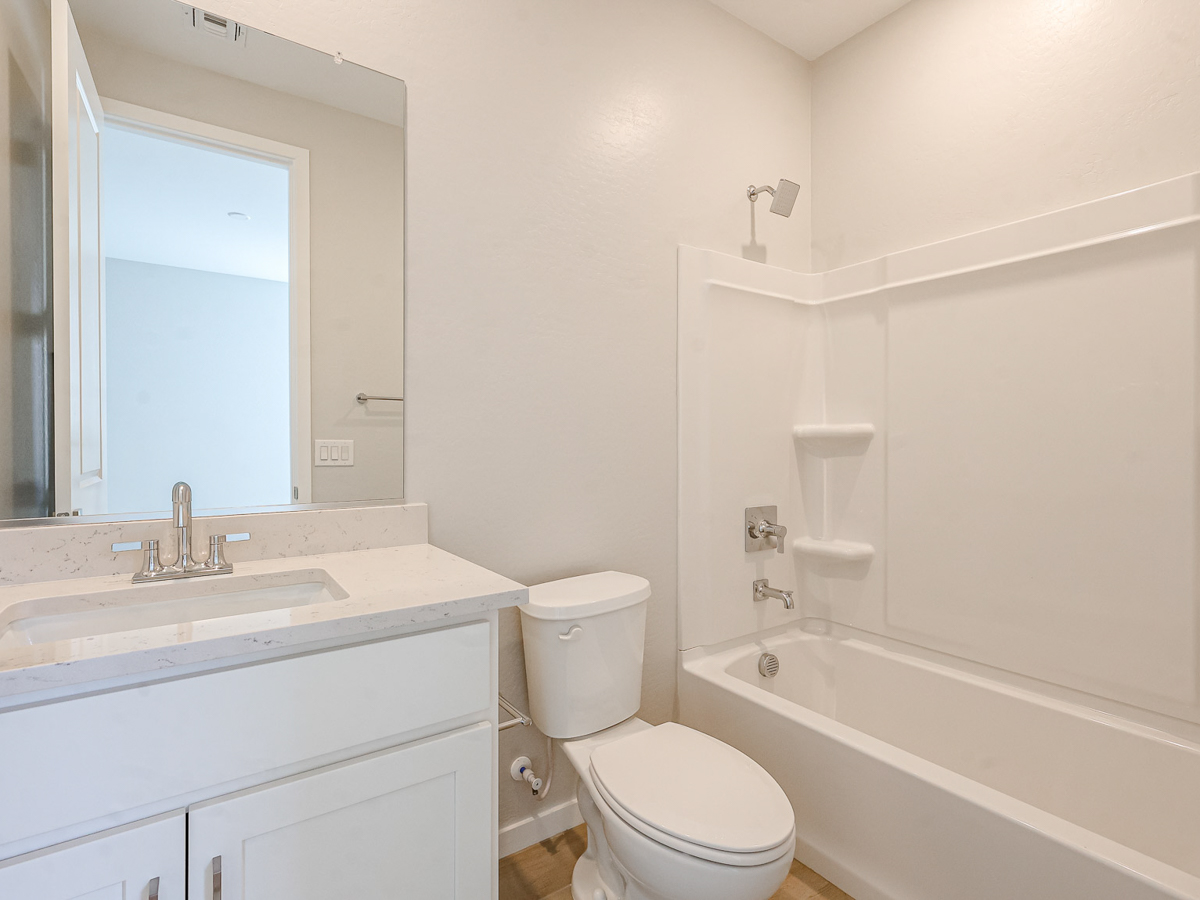A bathroom with a tub sink and toilet.