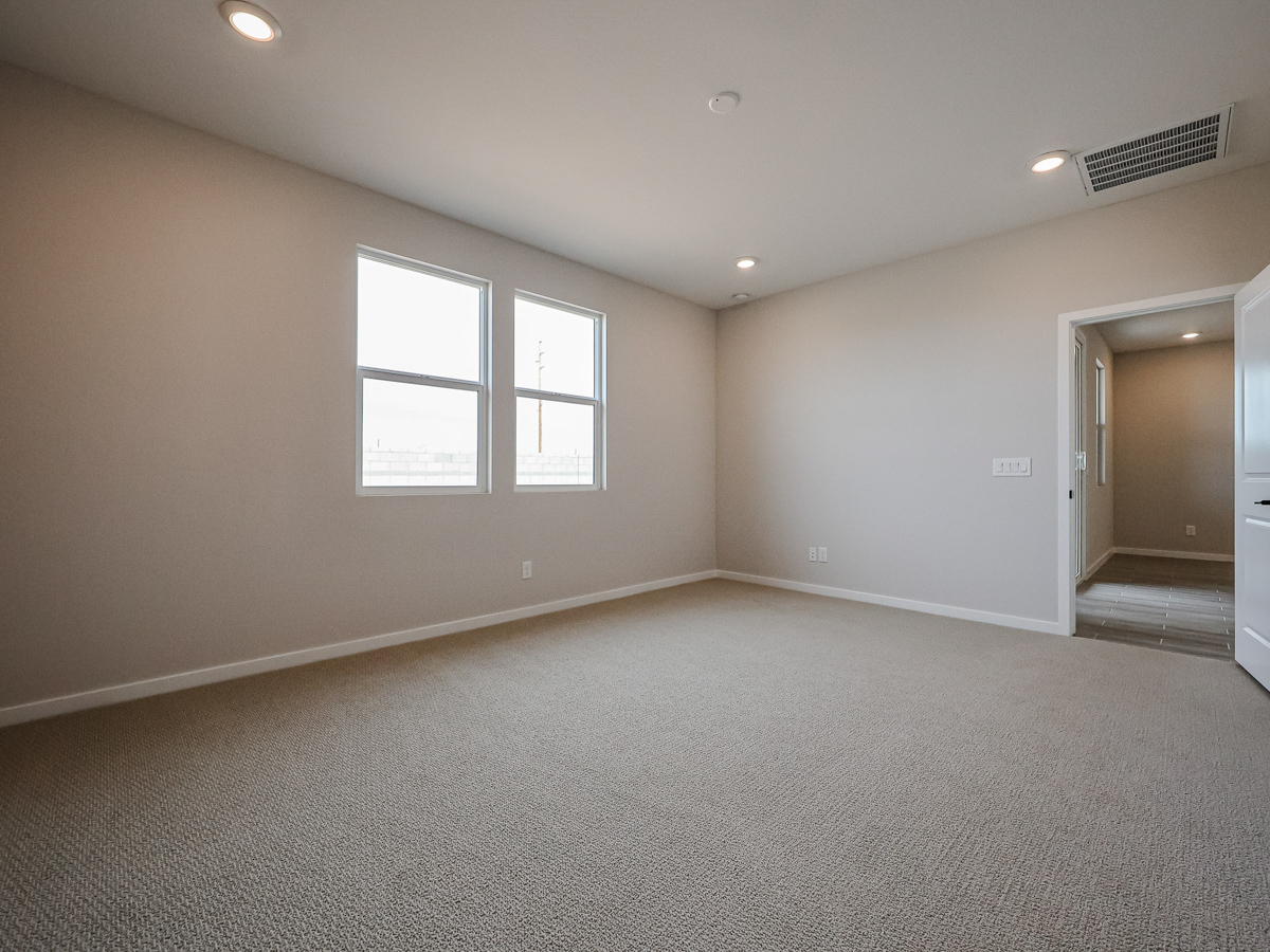 A room with a carpet and windows.