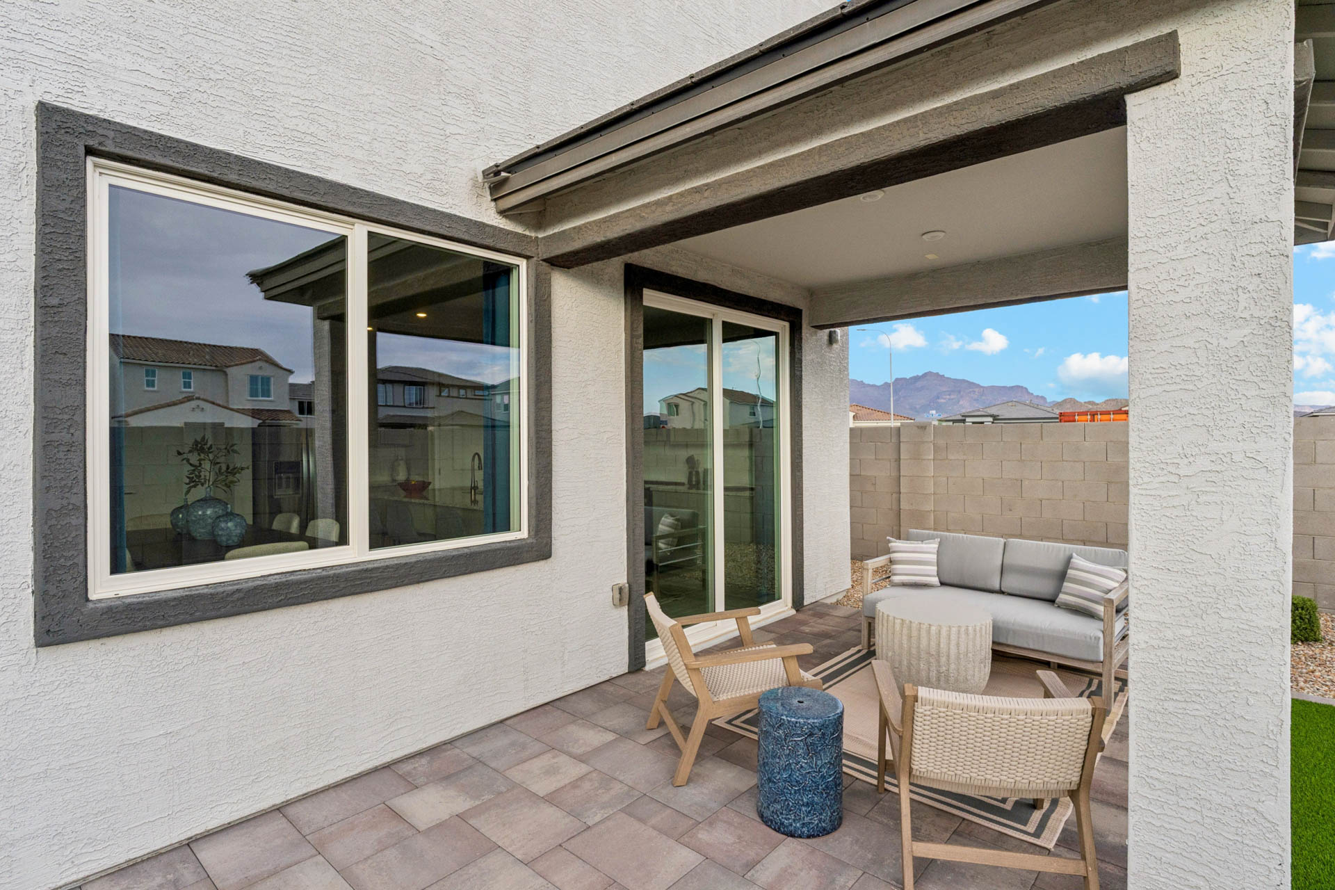 A patio with a bench and a table and chairs.