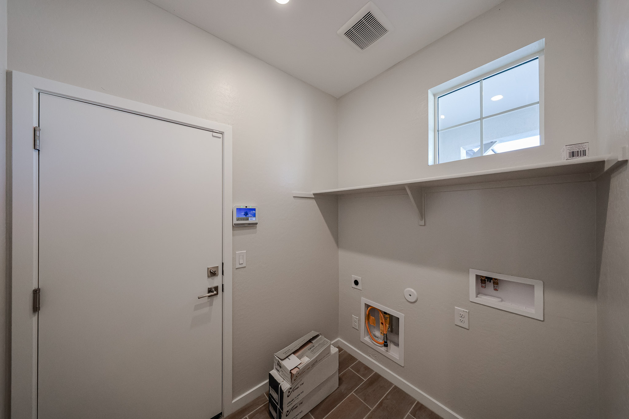 A room with a white door and a white wall with a window.