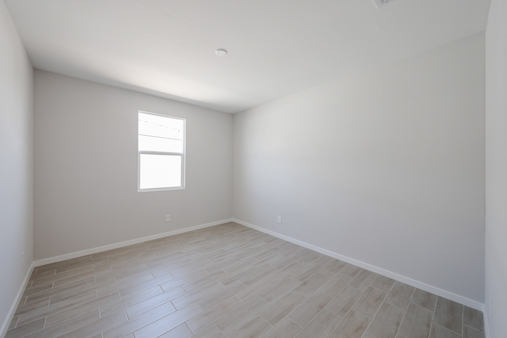 A room with a wood floor and a window.