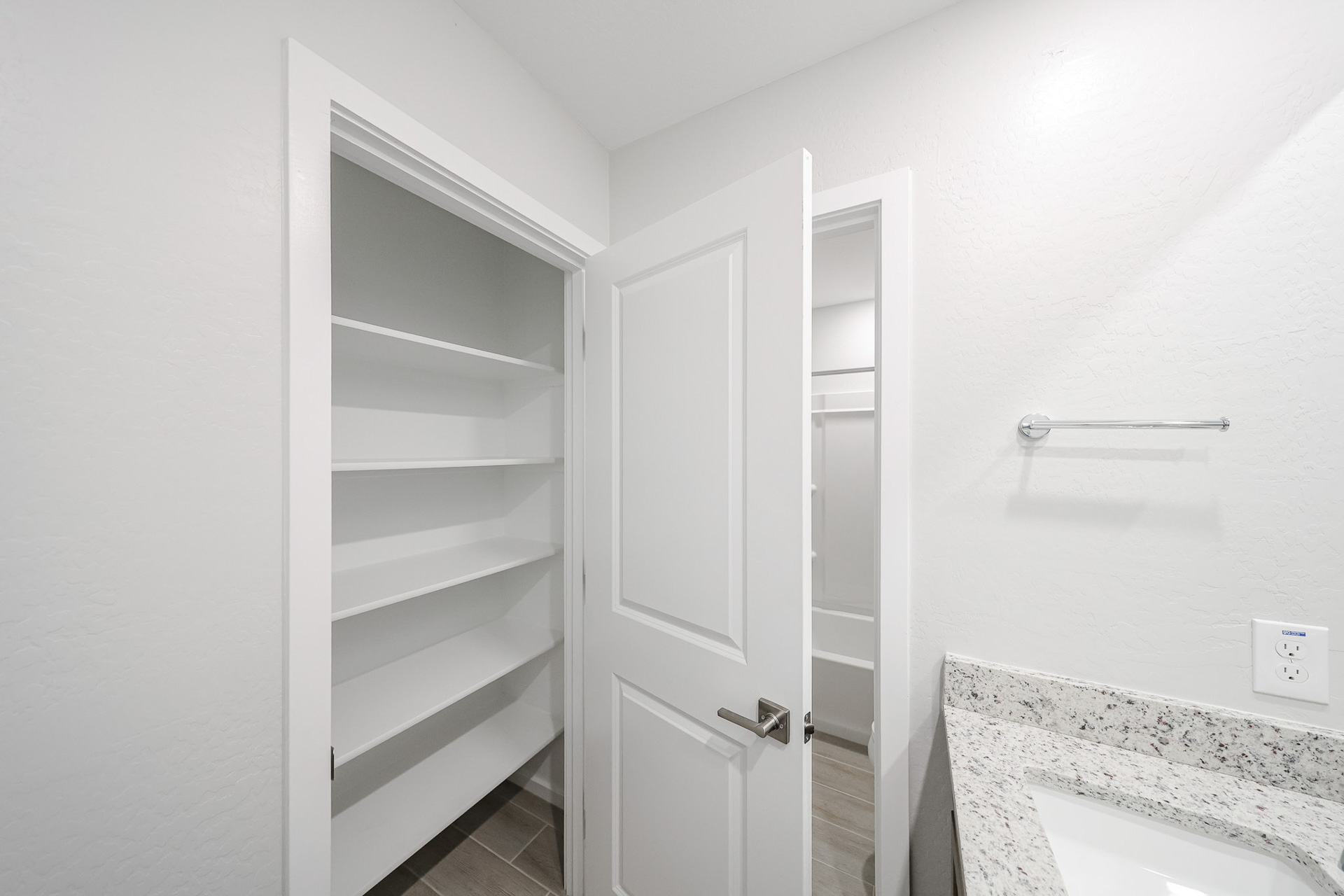 A white cabinet in a bathroom.