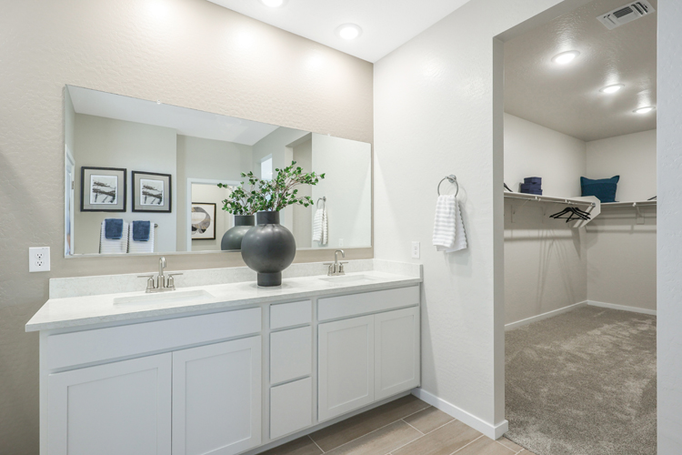 A bathroom with white cabinets.