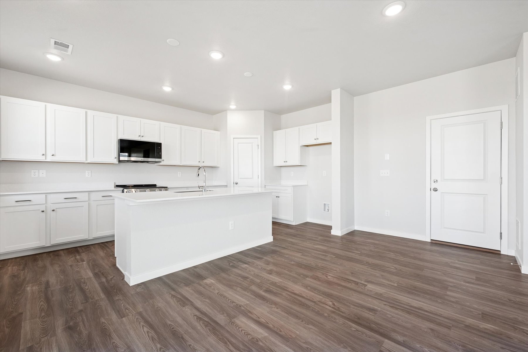 A kitchen with white cabinets.