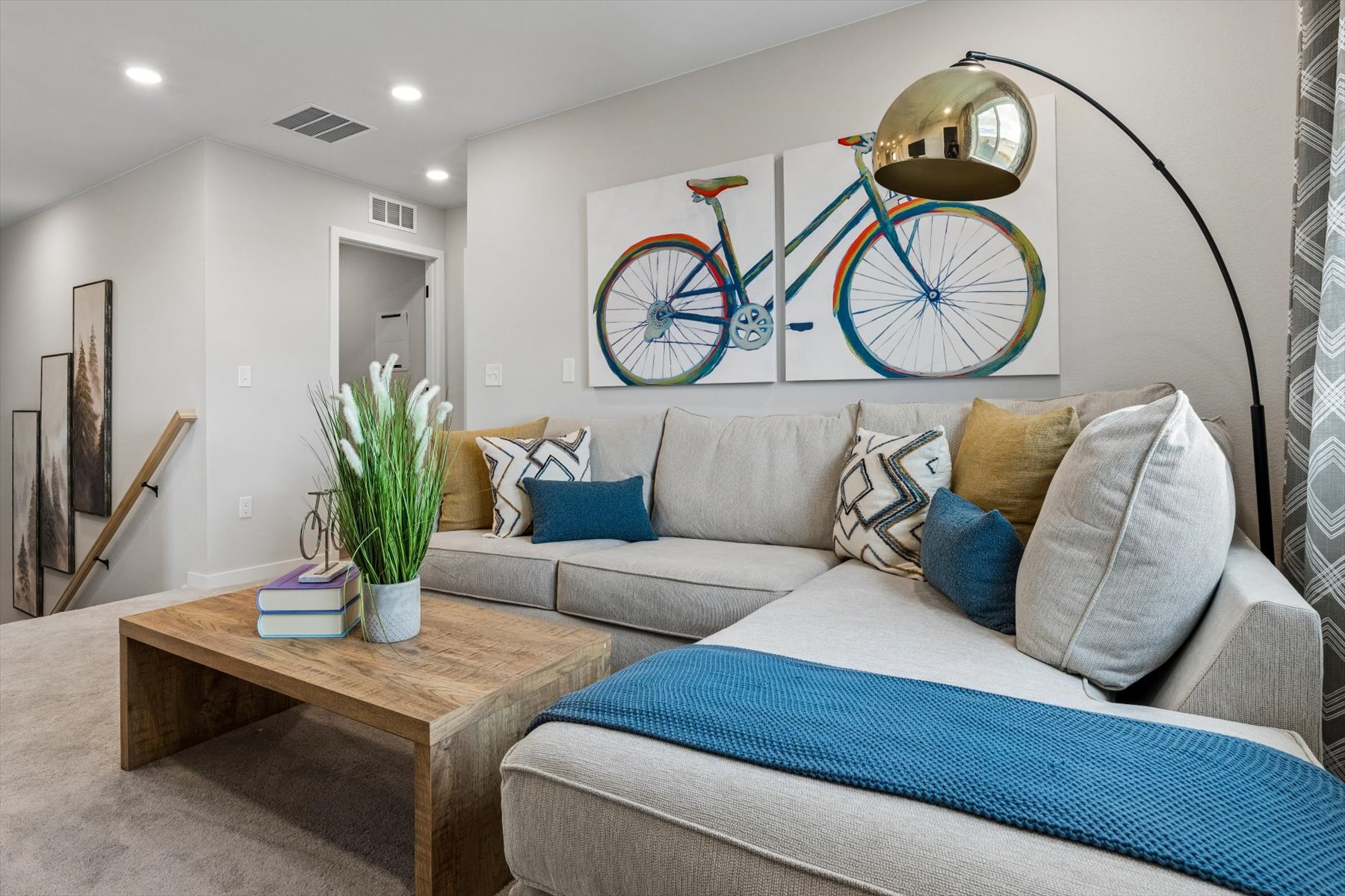 A living room with a couch and a bike on the wall.