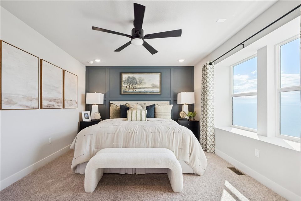 A bedroom with a bed and a fan.