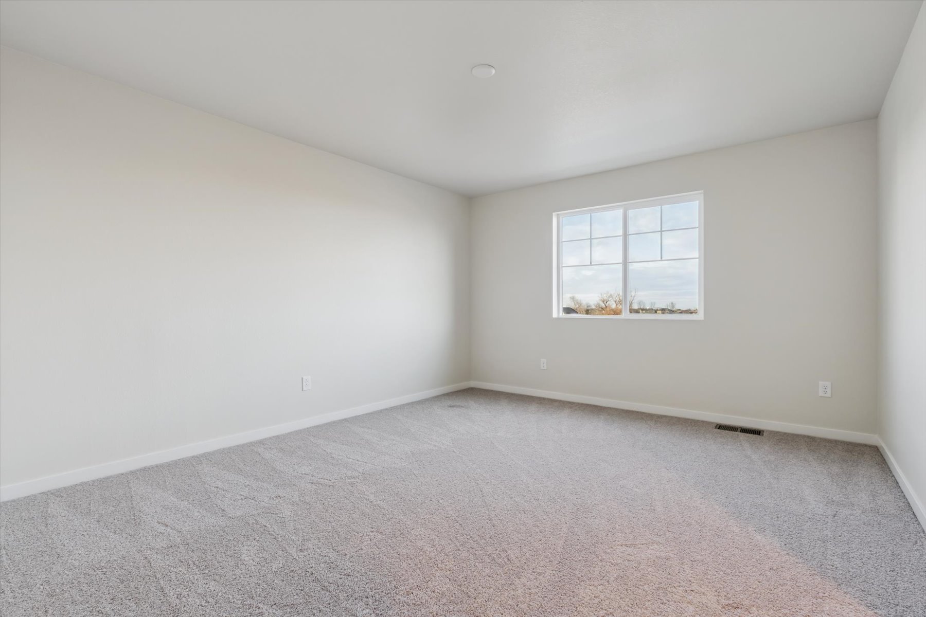 A room with a window and carpet.