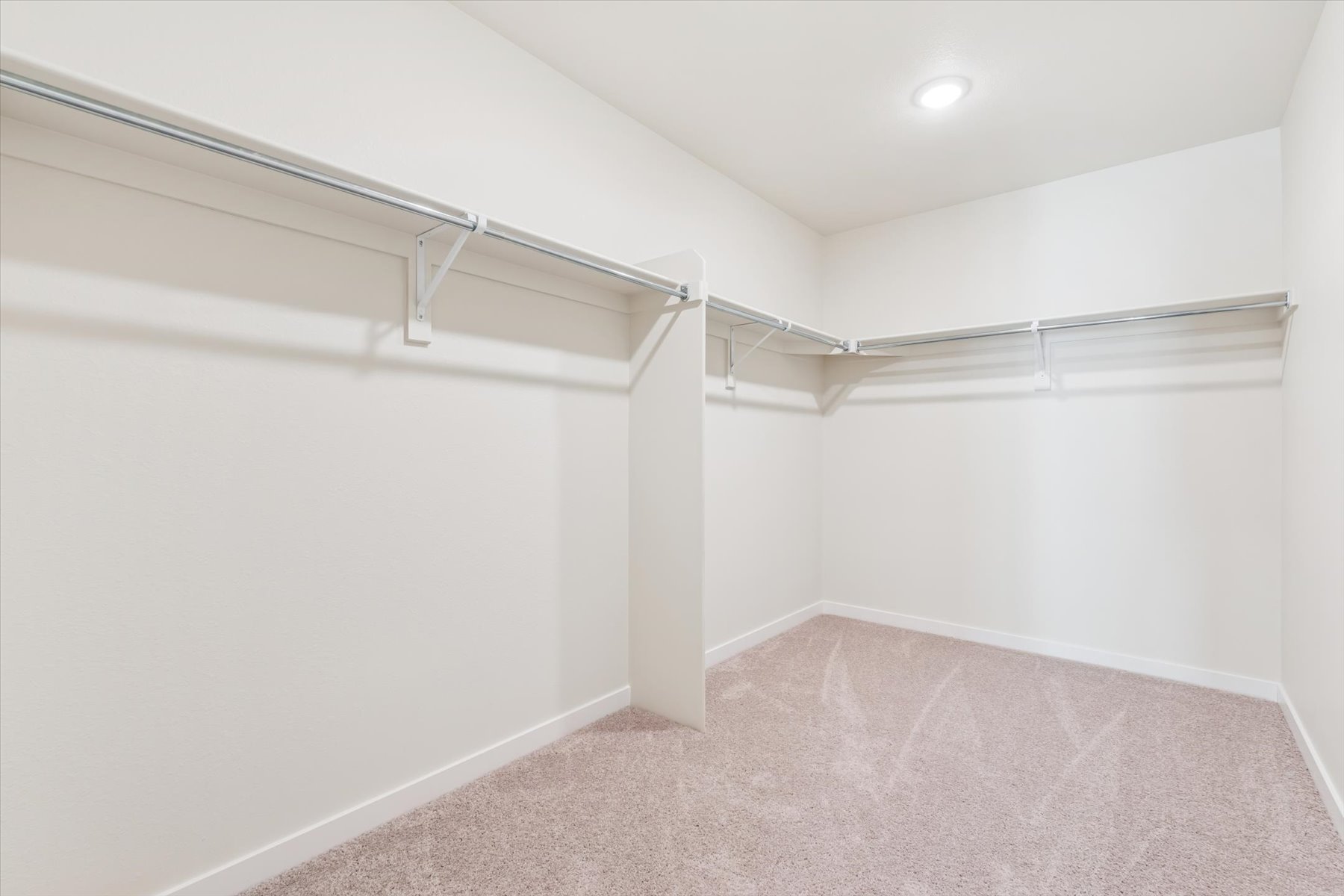 A white hallway with a metal railing.