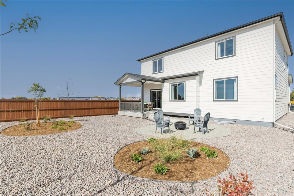 A house with a patio and a table and chairs in the front.