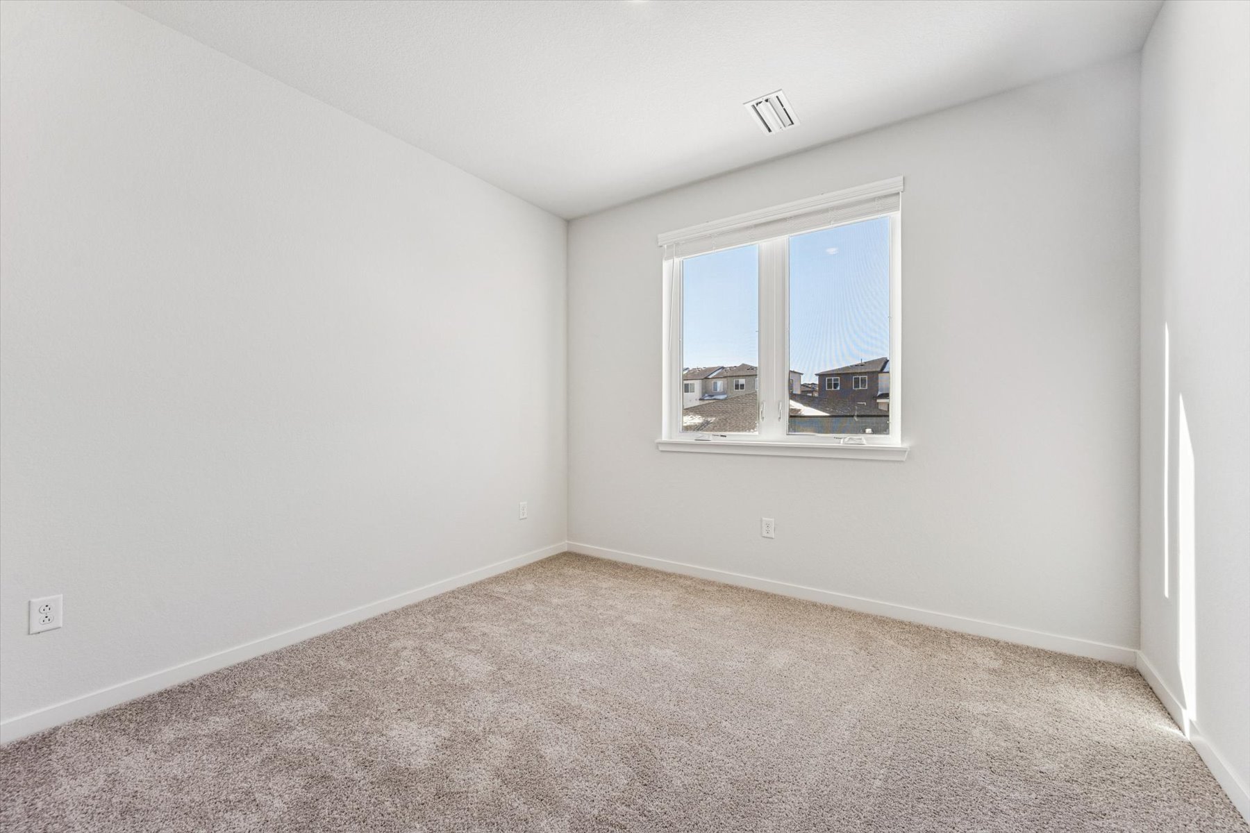 A room with a window and carpet.
