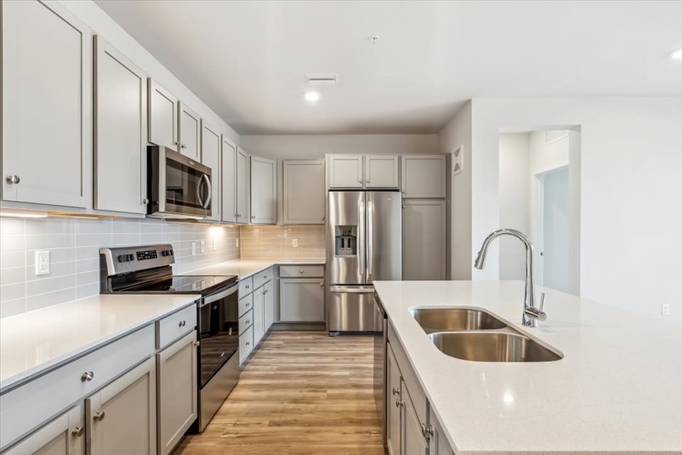 A kitchen with white cabinets.