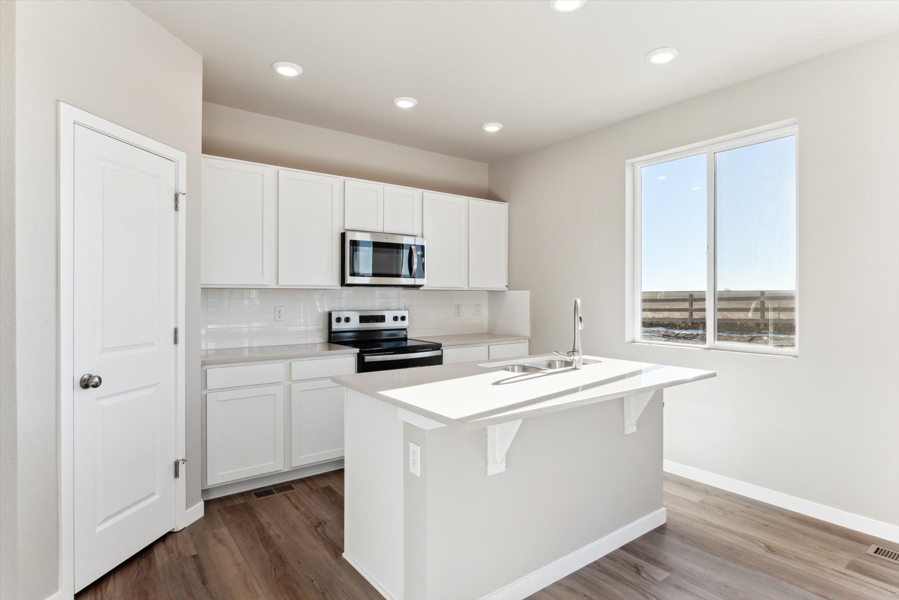 A kitchen with white cabinets.