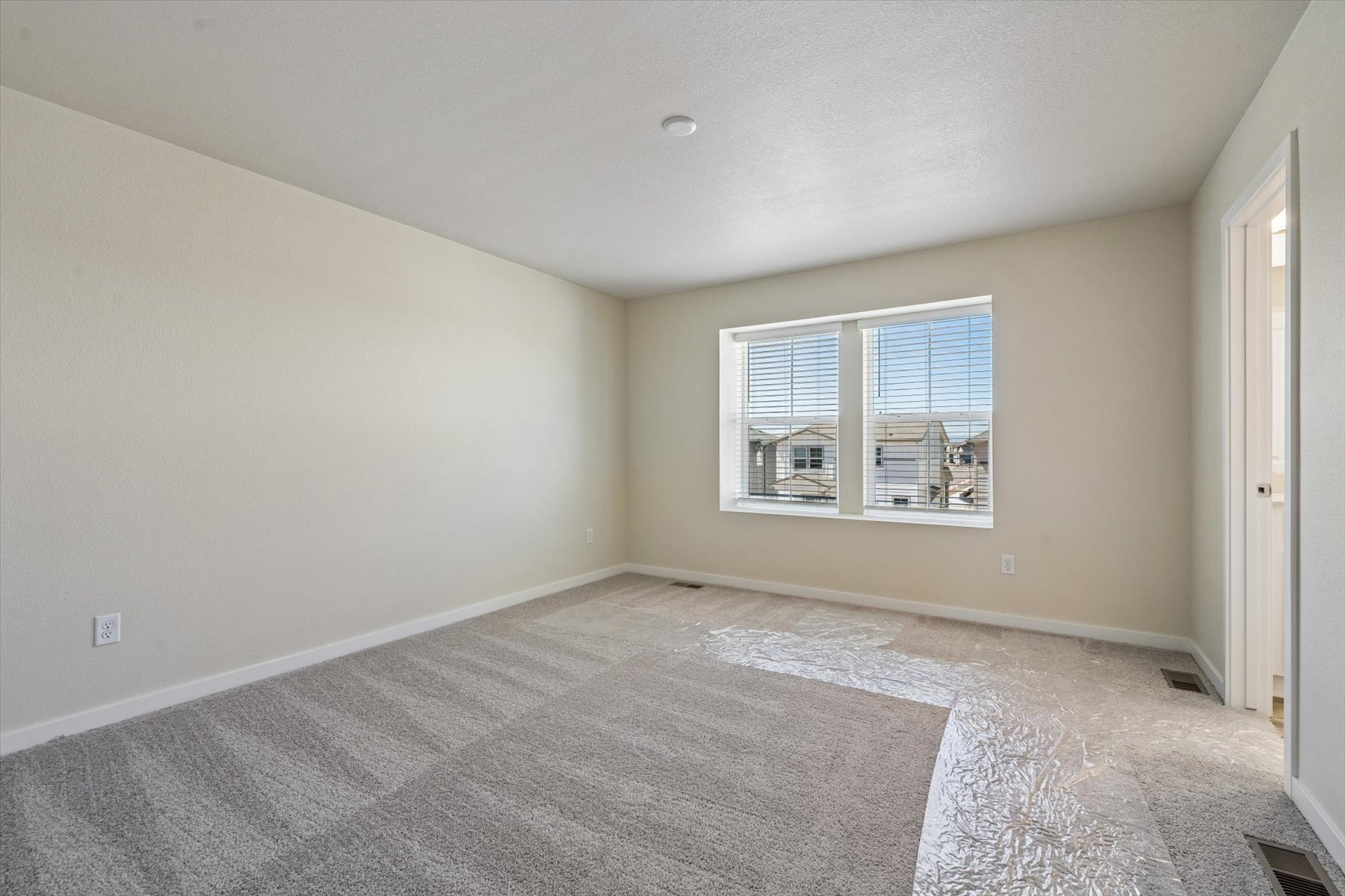 A room with a carpet and a window.