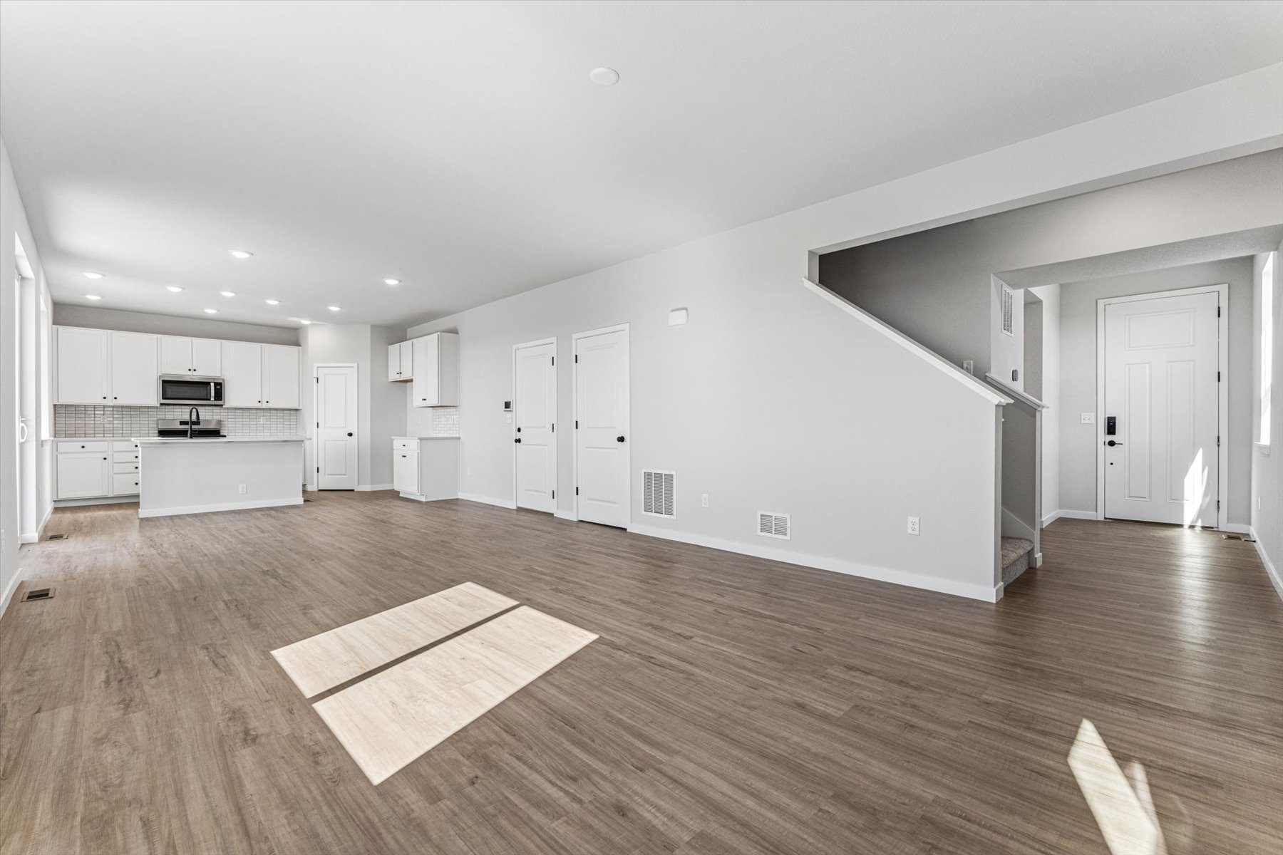 A large empty room with white doors.