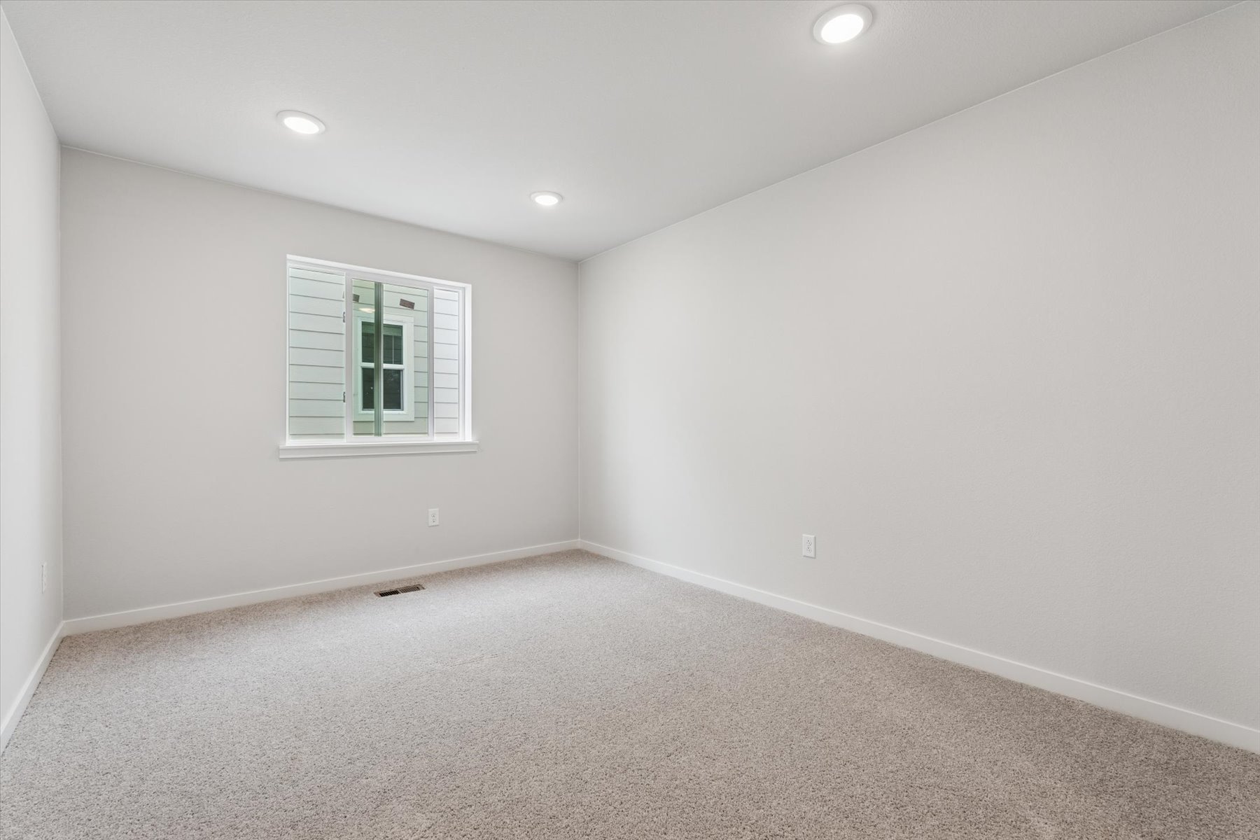 A room with a window and a carpet.