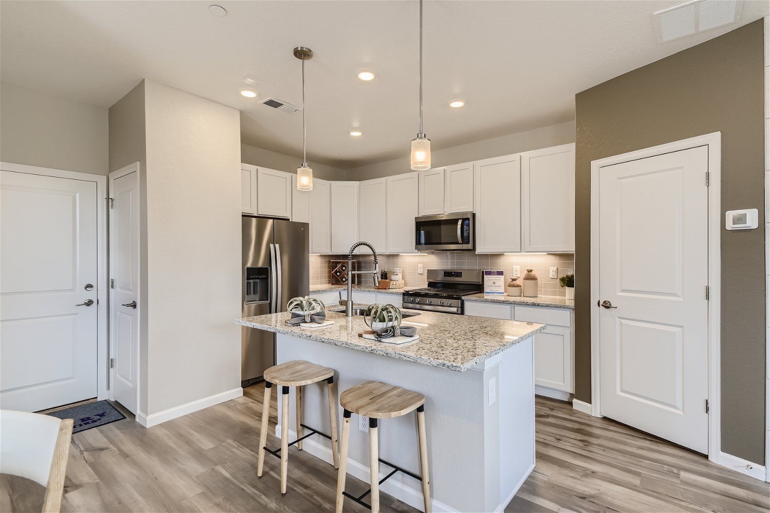 A kitchen with white cabinets.