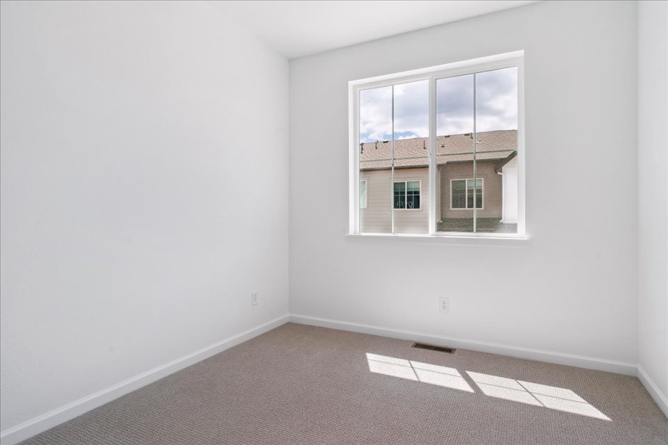 A room with a window and a carpet.