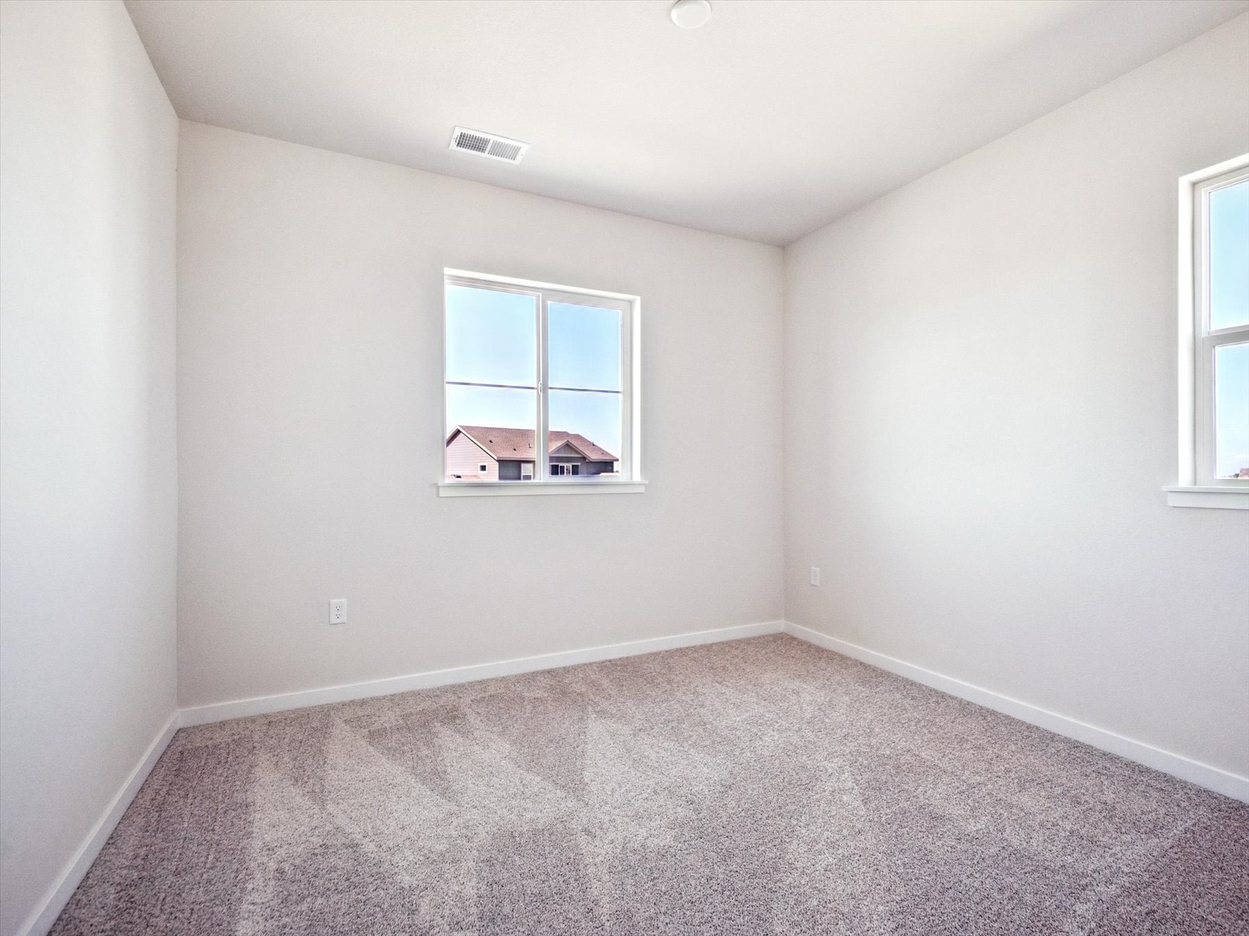 A room with a window and a carpet.