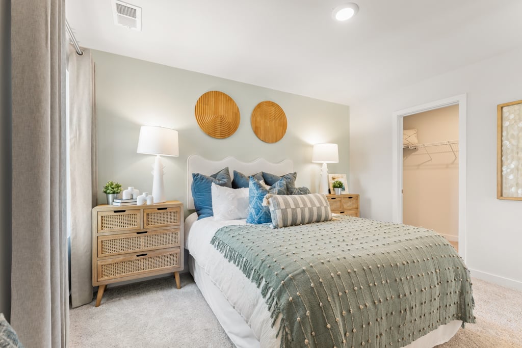 A bedroom with a bed and lamps.