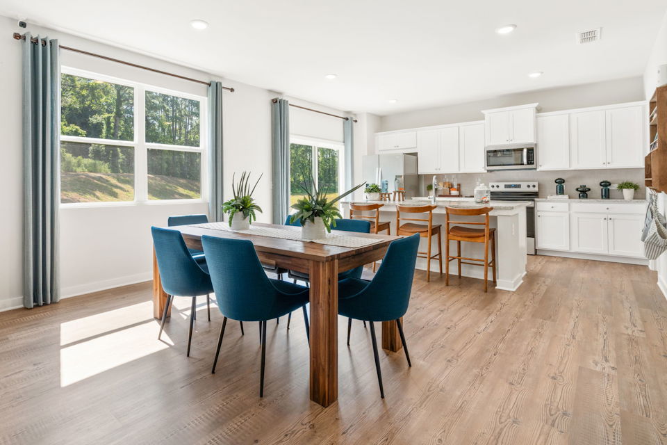 A kitchen with a table and chairs.