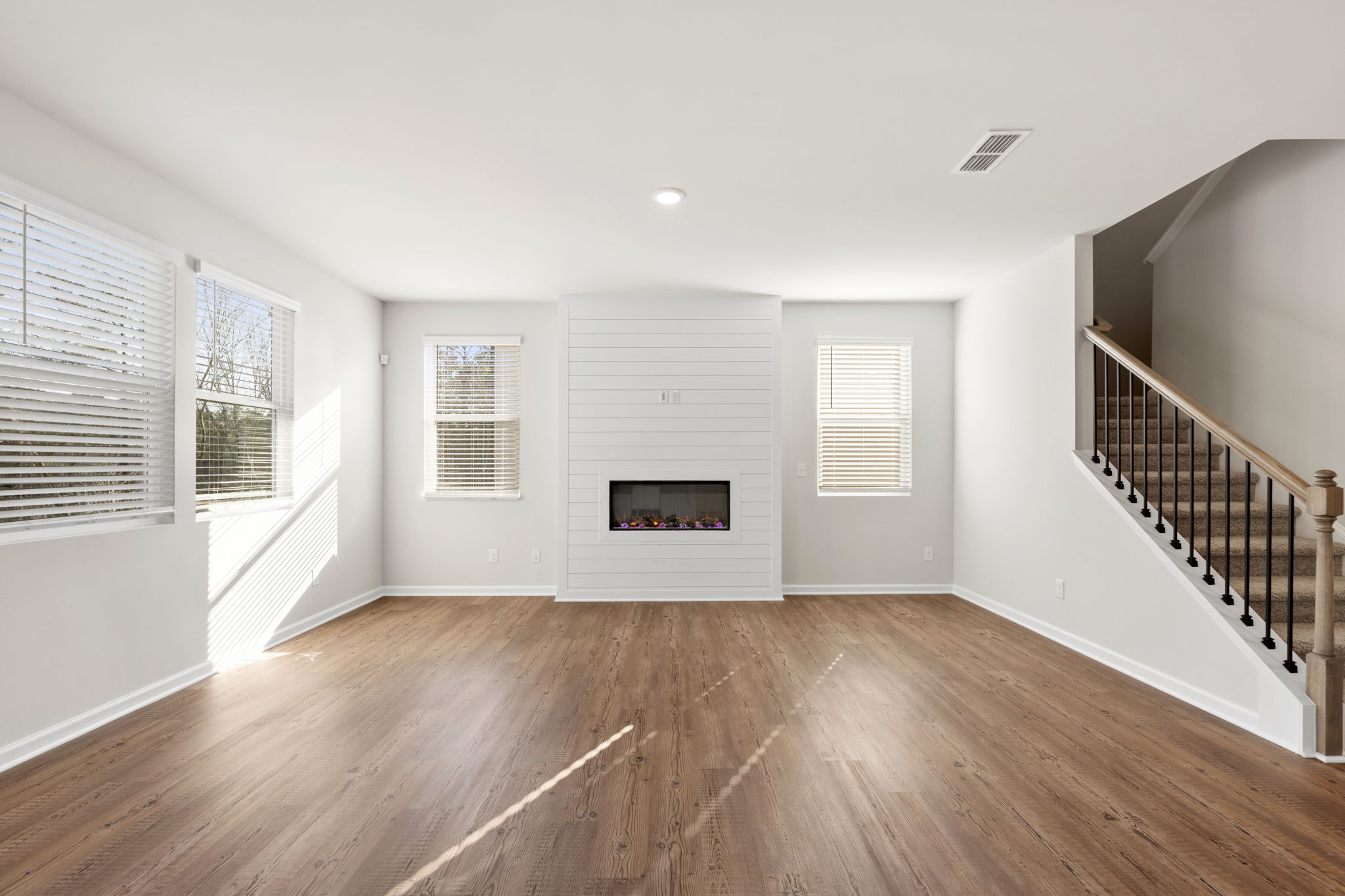 A room with a wood floor and white walls.
