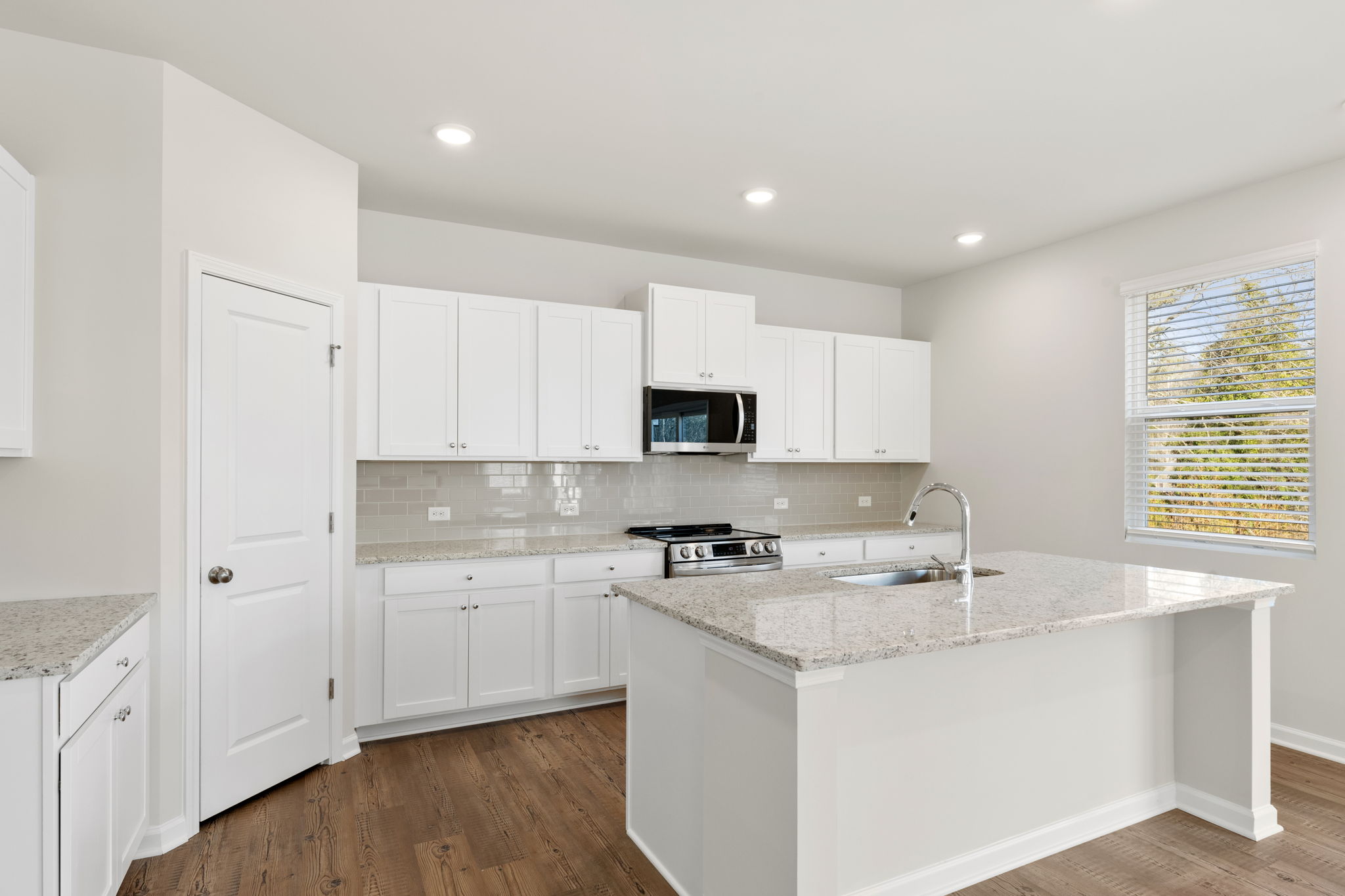 A kitchen with white cabinets.