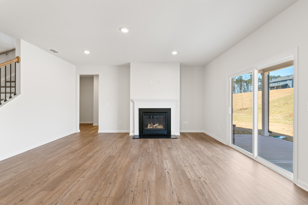 A room with a fireplace and a wood floor.
