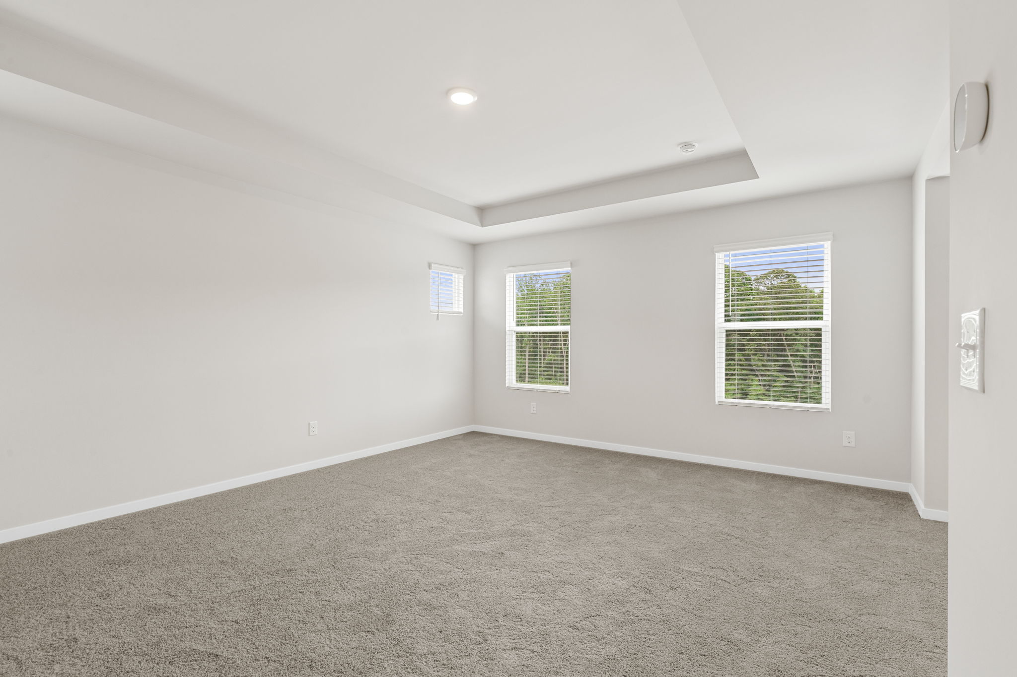 A room with a window and a carpet.