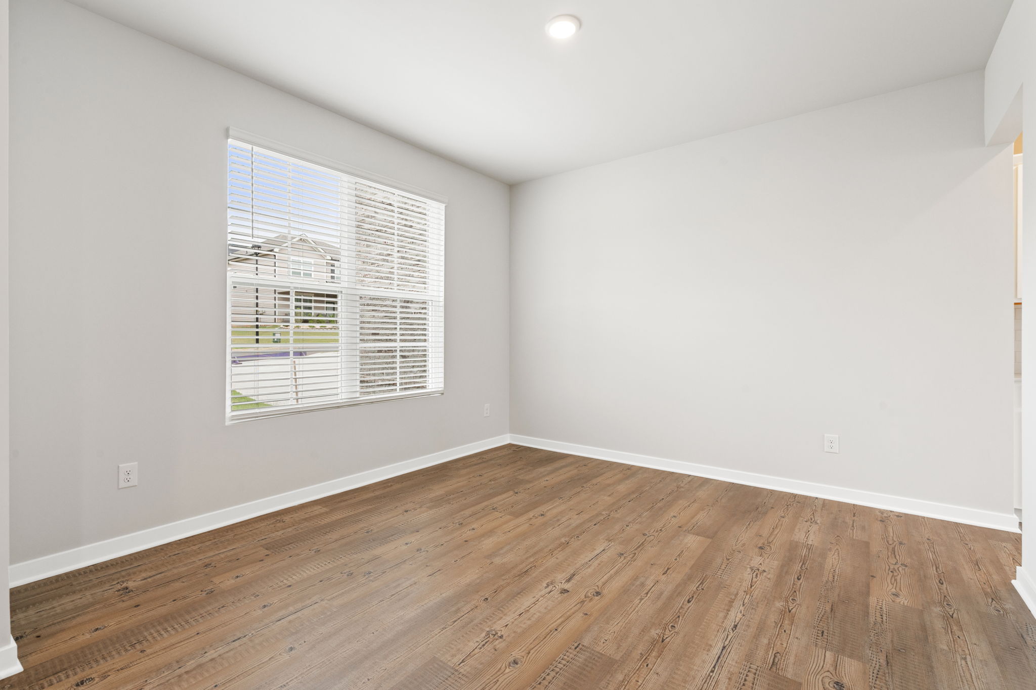 A room with a wood floor and a window.