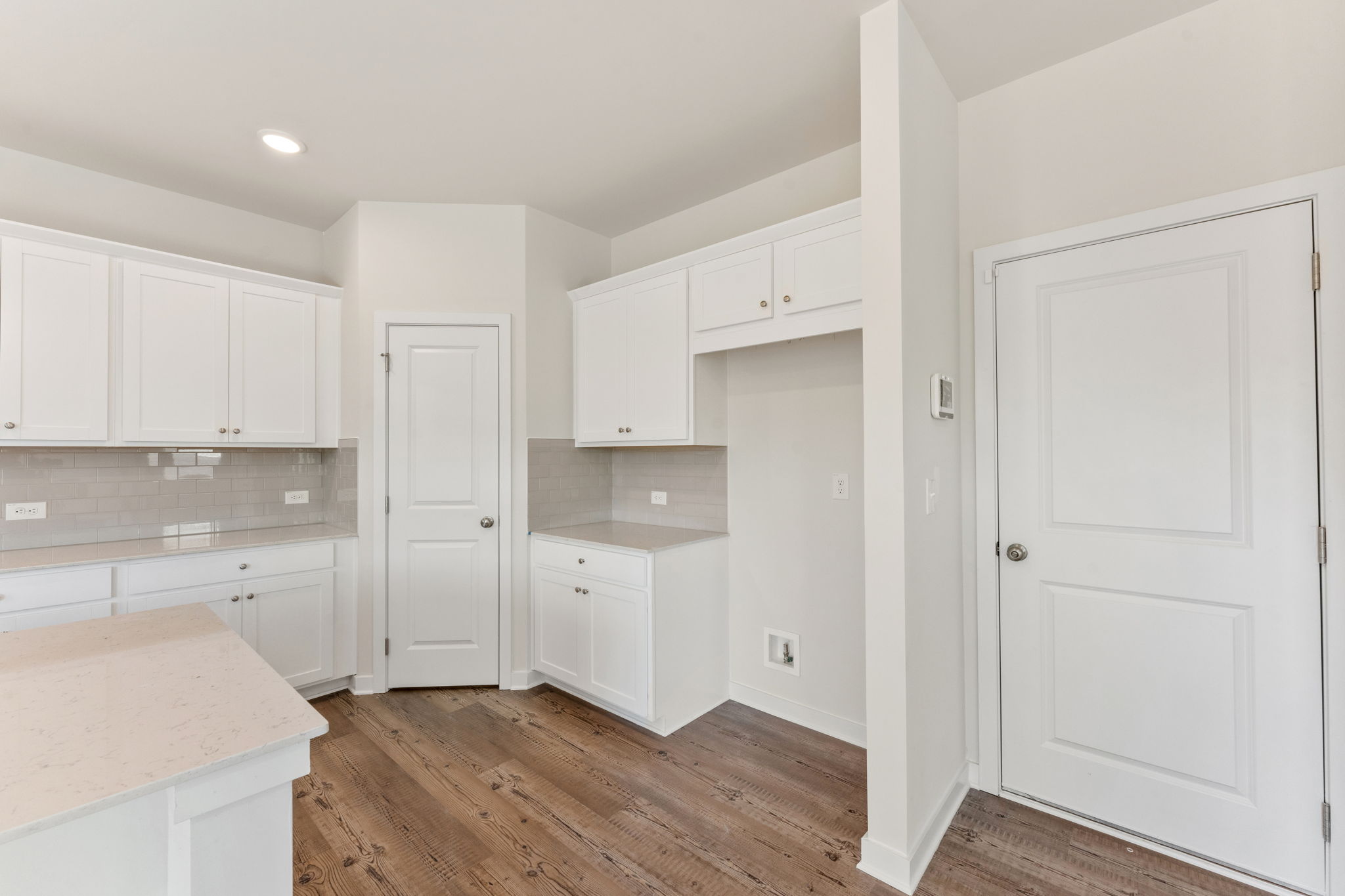 A kitchen with white cabinets.