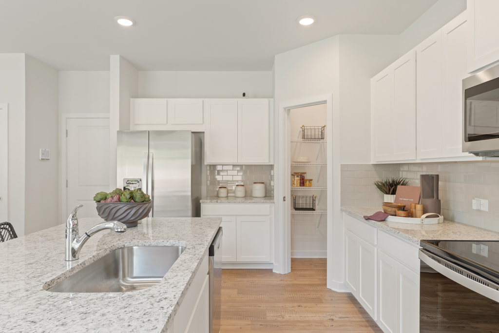 A kitchen with white cabinets.